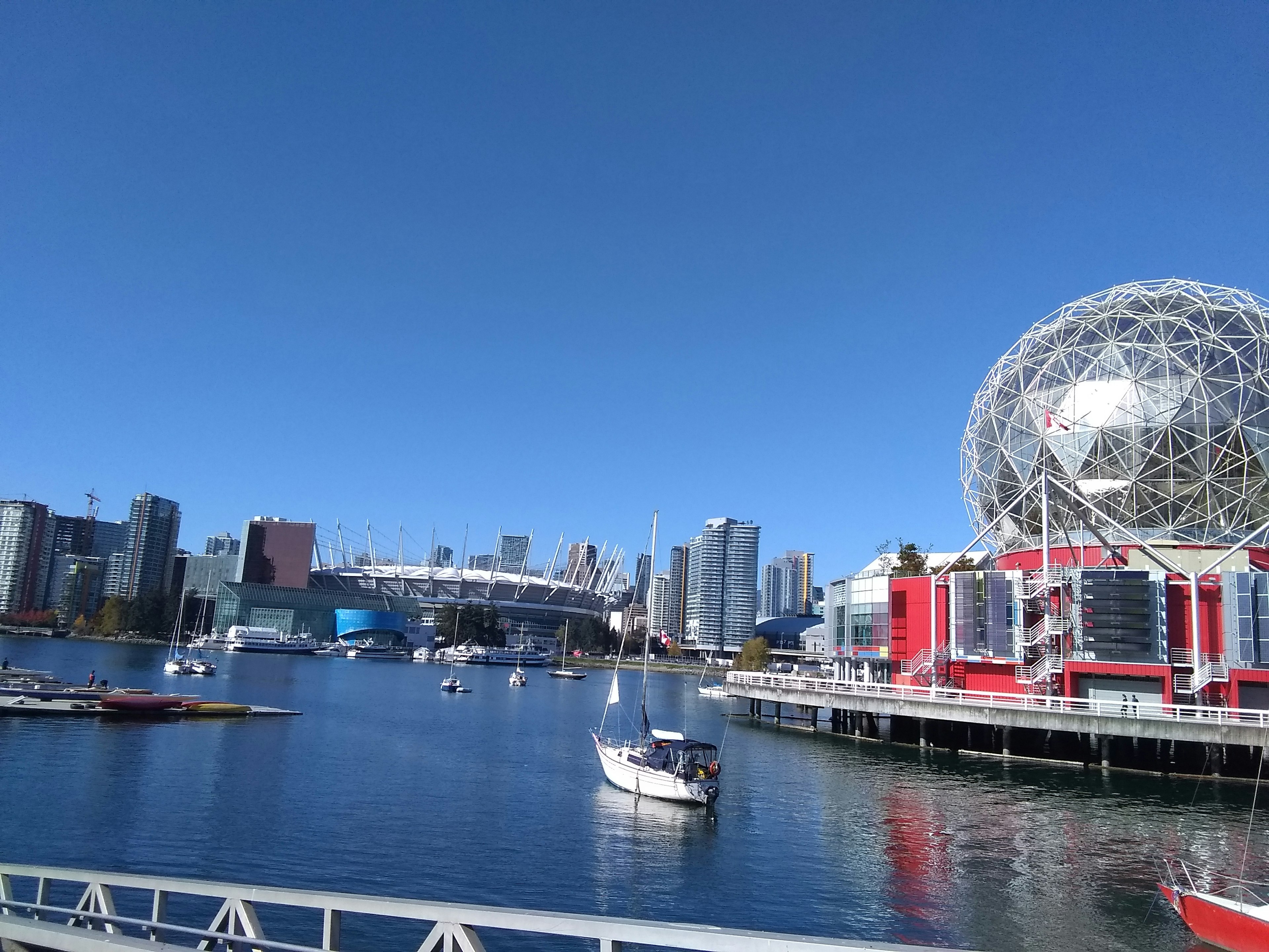 Paisaje urbano bajo un cielo azul con barcos en el agua