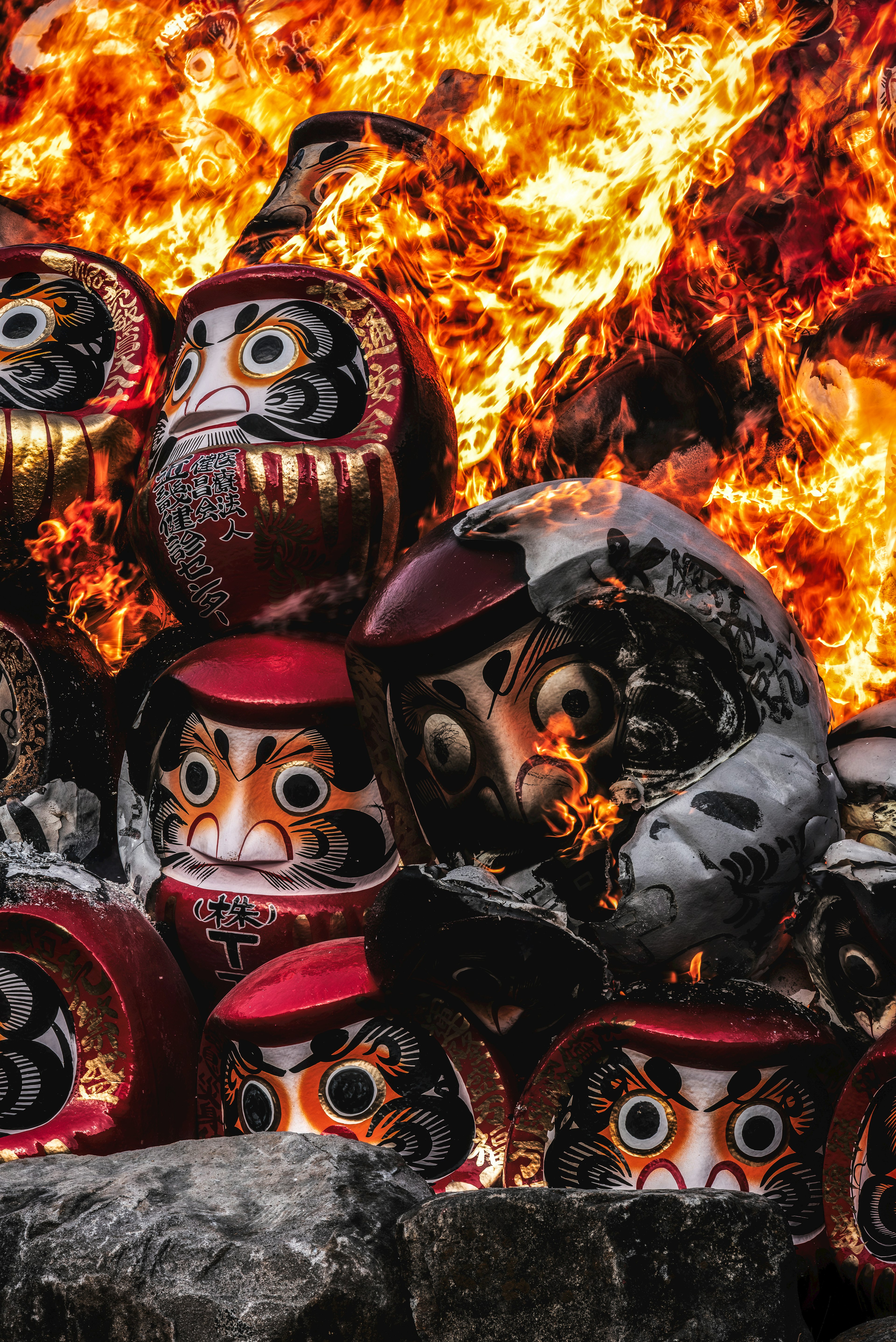 Daruma dolls stacked amidst flames