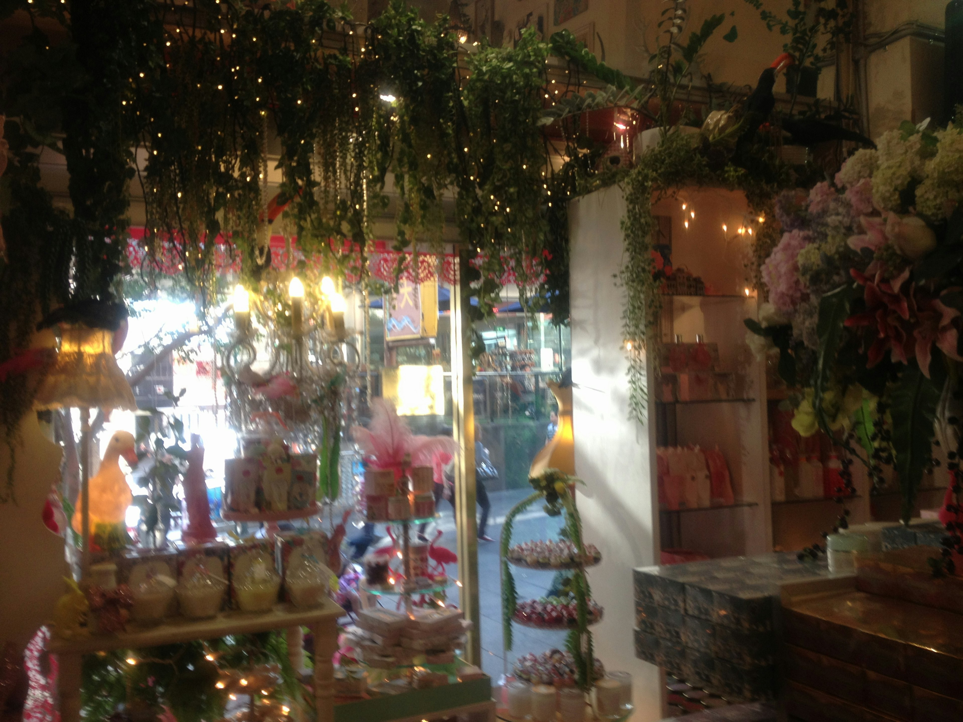 Interior de una floristería con decoraciones verdes y luces parpadeantes