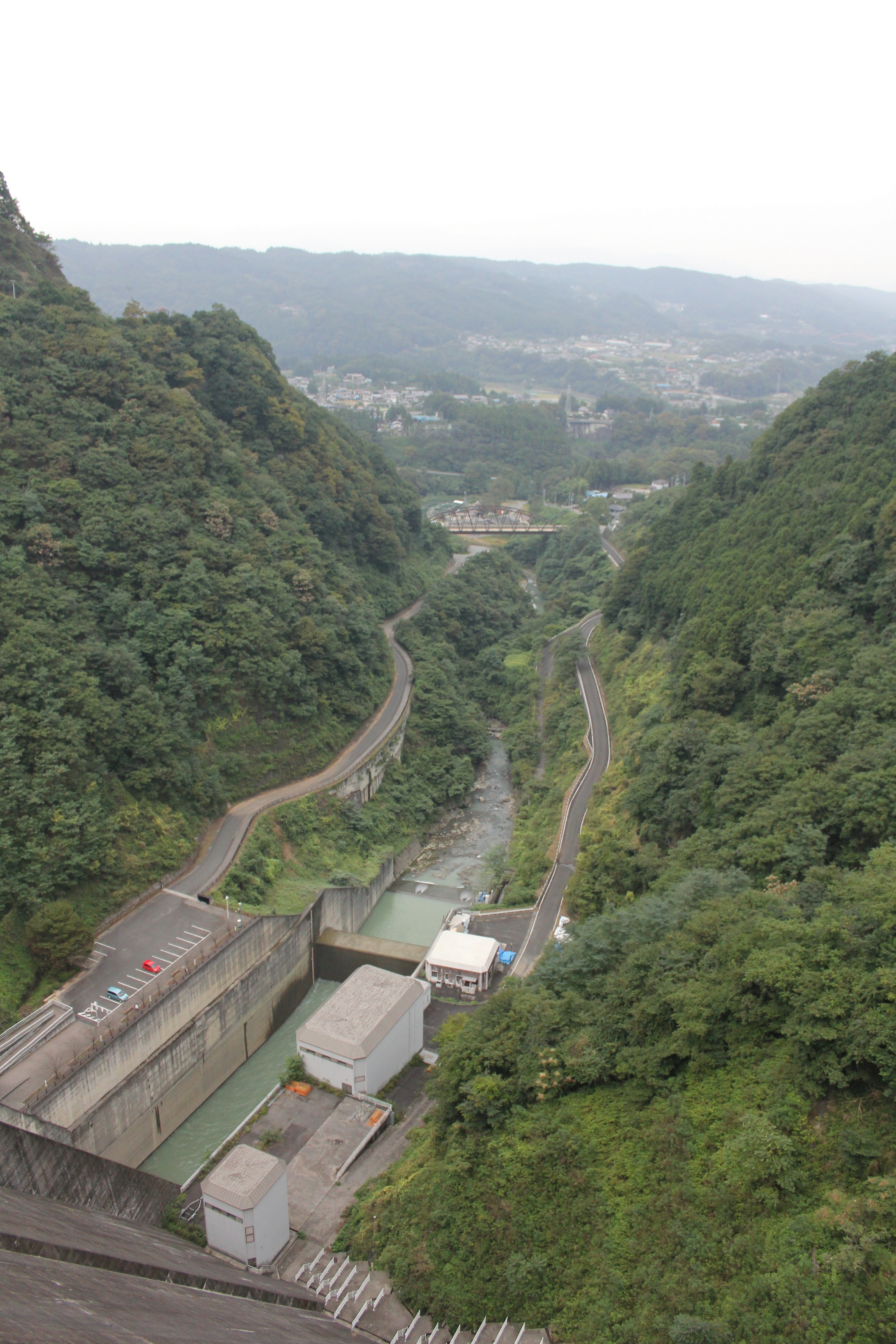 山々に囲まれた谷間の風景 ダムと川が見える