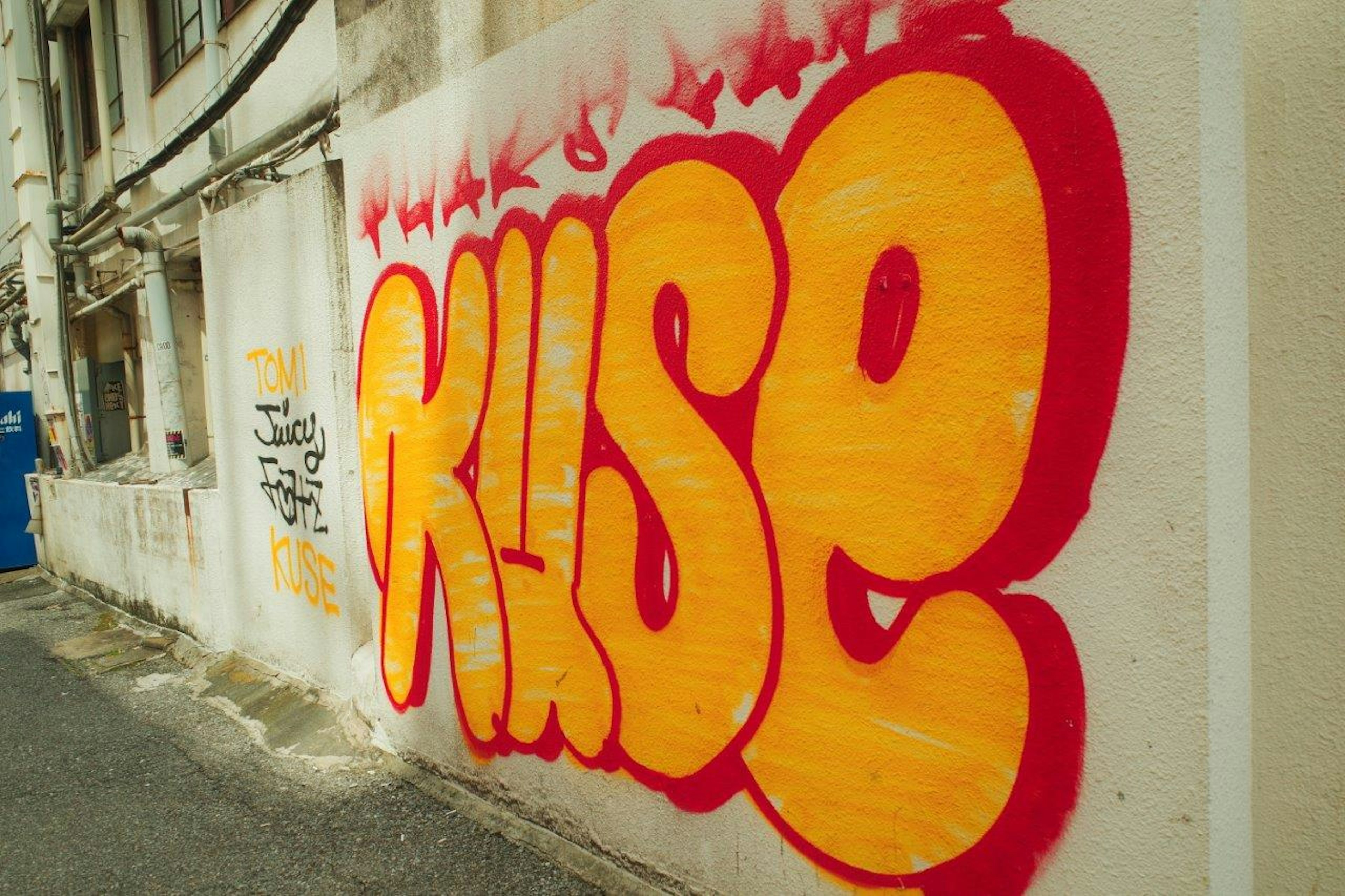 Art de graffiti sur un mur avec le mot 'KUSE' en rouge et orange