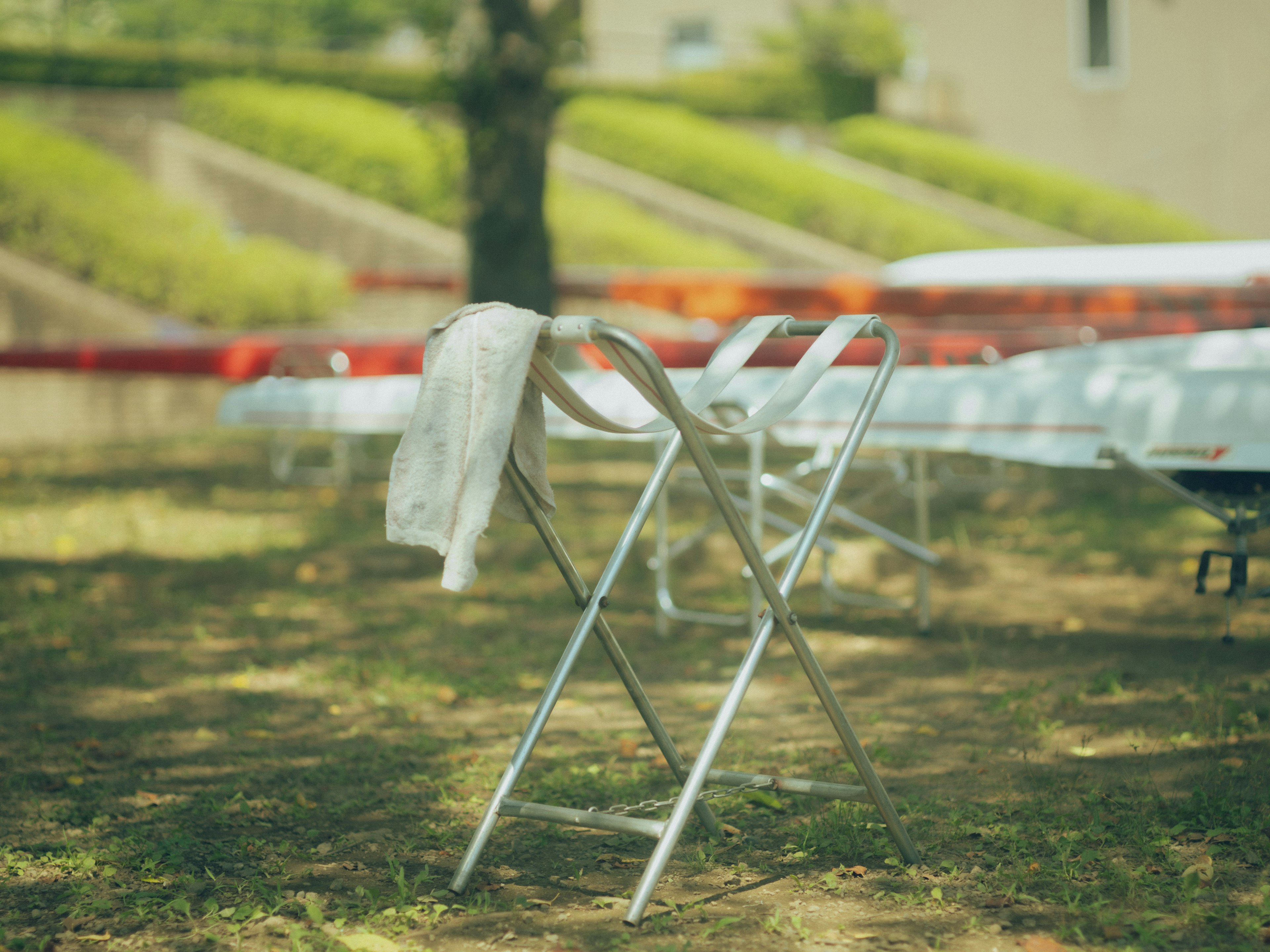 Une chaise pliante en extérieur avec une serviette drapée dessus