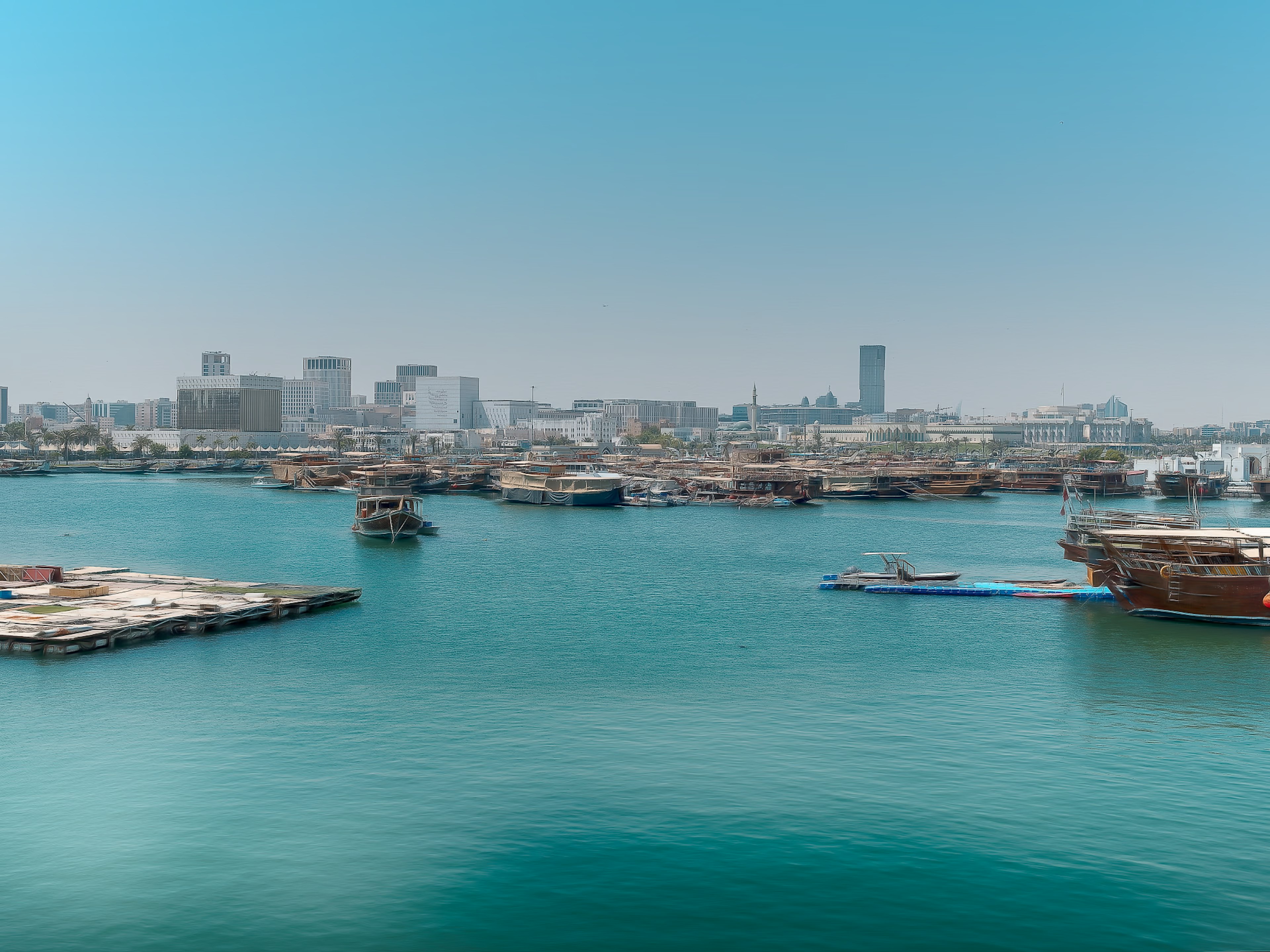 Horizonte de la ciudad con barcos en agua turquesa