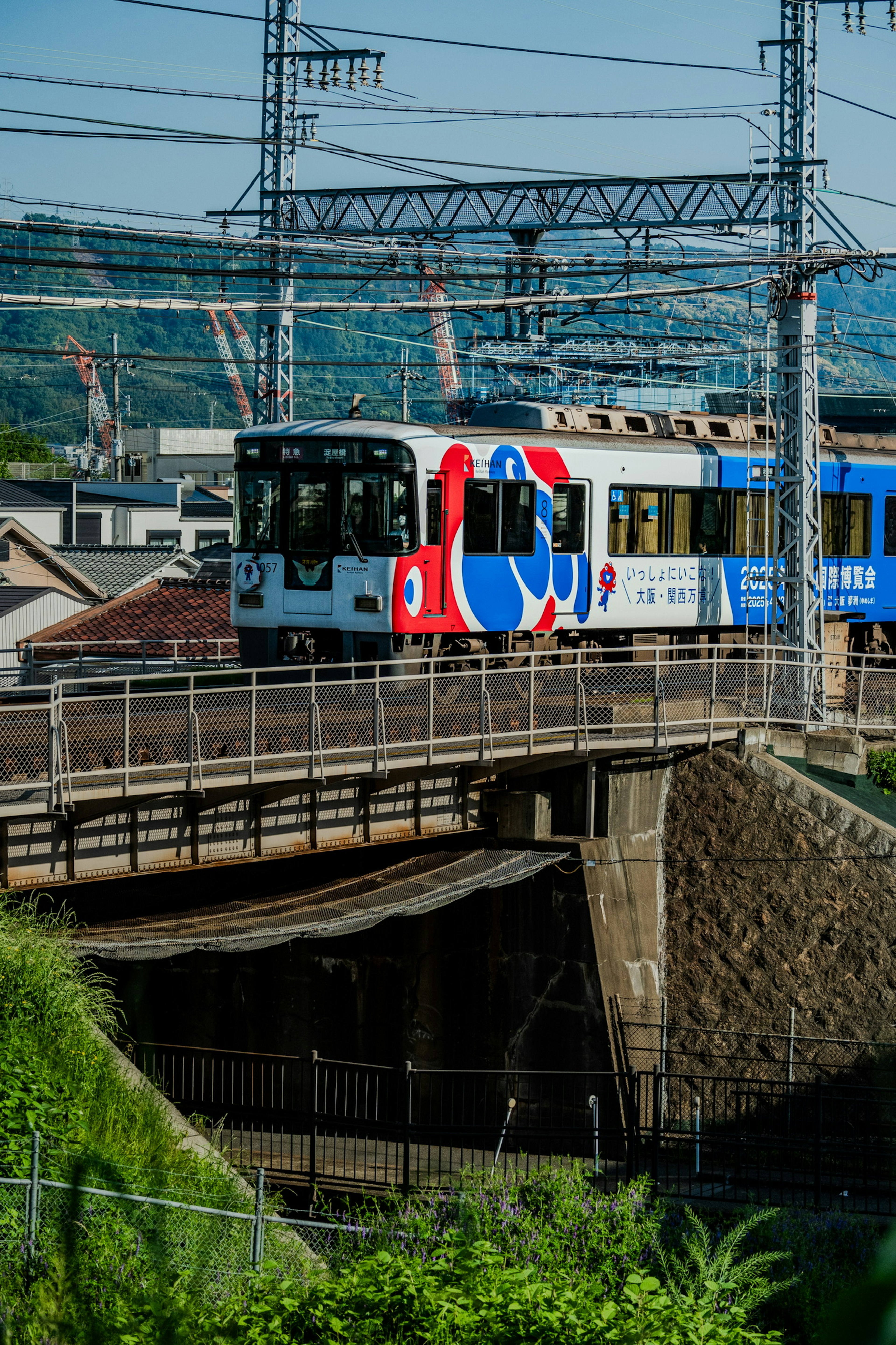 カラフルなデザインの電車が橋を渡っている風景