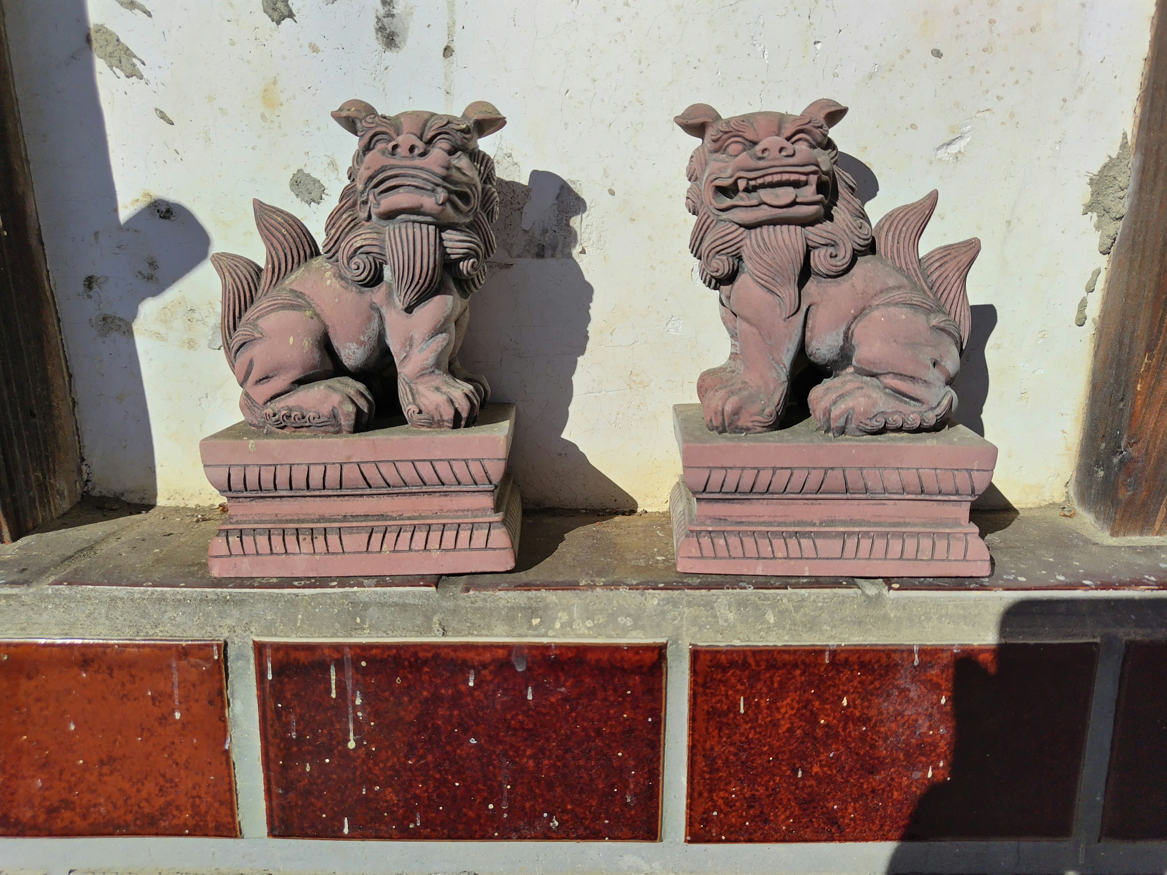 Two lion statues displayed side by side on a stone base