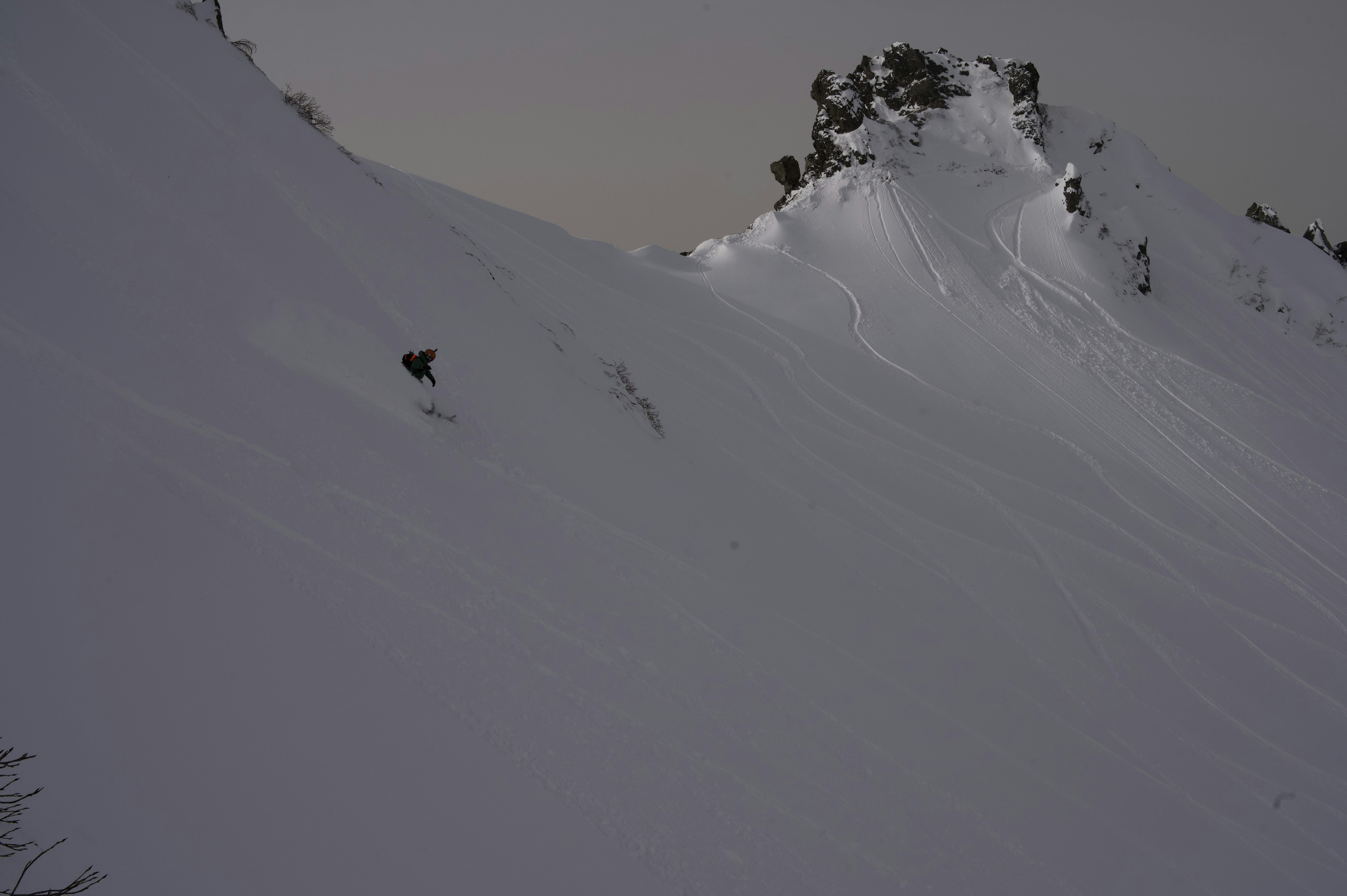 Pendio di montagna coperto di neve con sporgenza rocciosa