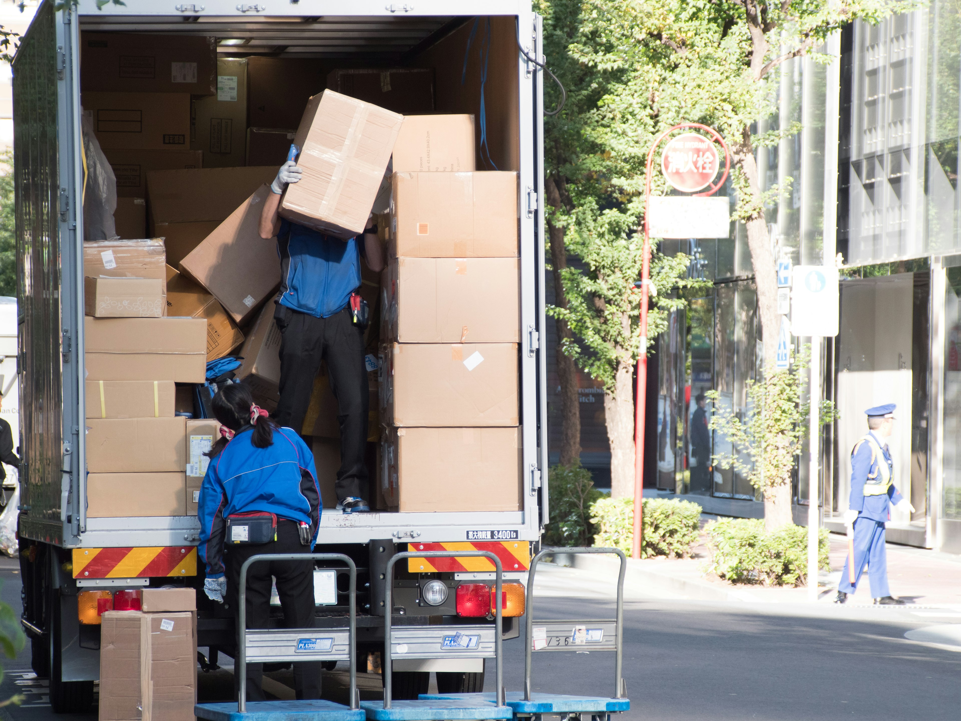 Workers unloading cardboard boxes from a truck