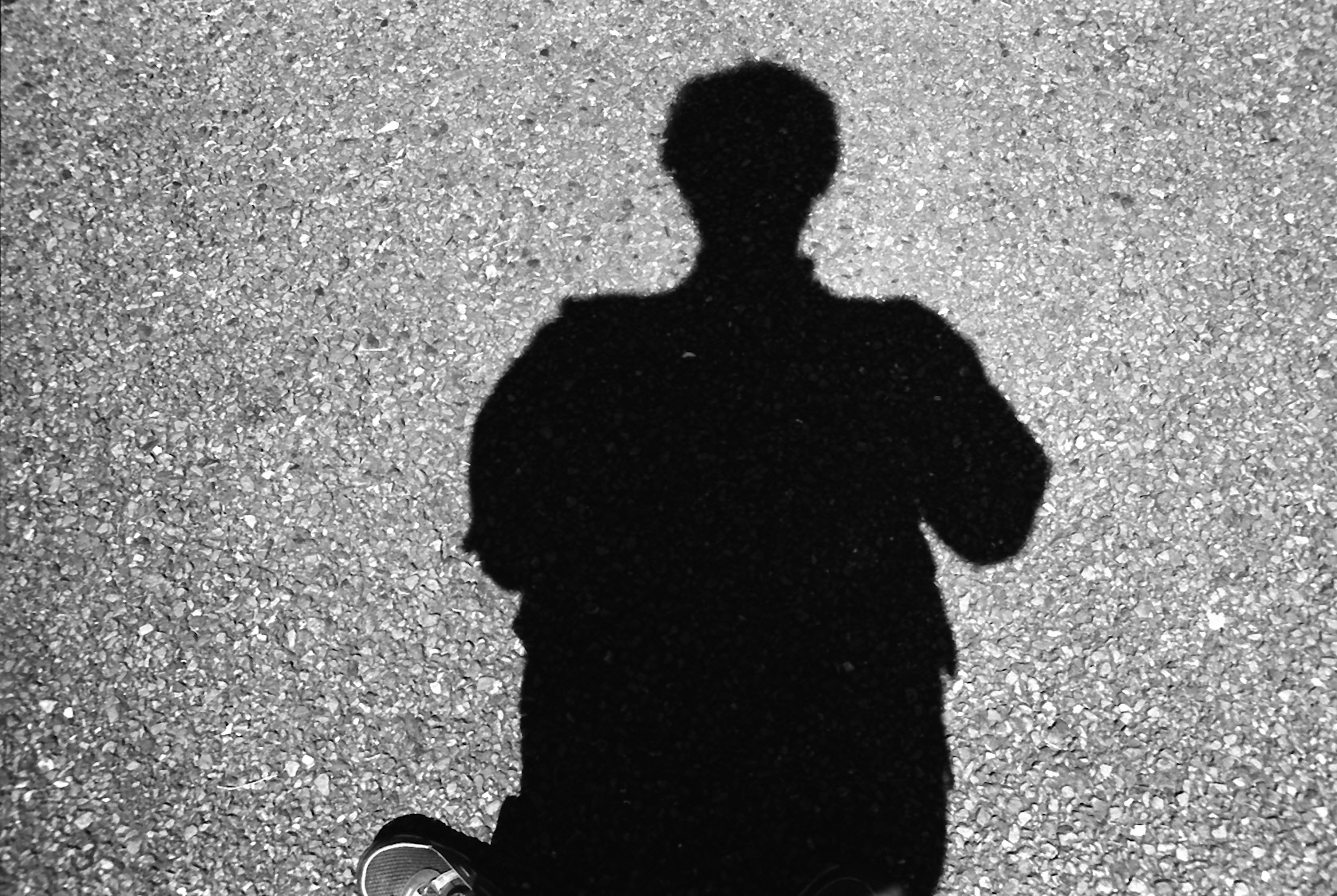 Monochrome image of a person's shadow on the ground