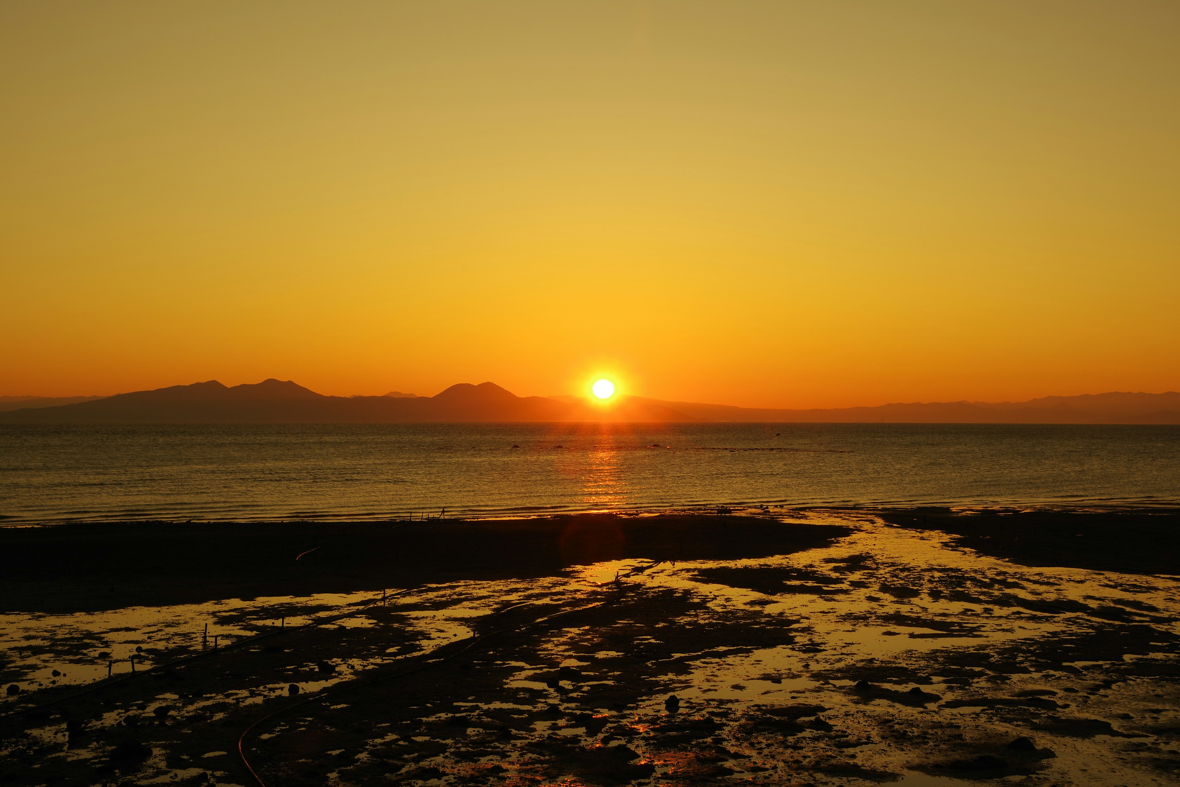 Schöne Aussicht auf einen orangefarbenen Sonnenuntergang über dem Meer