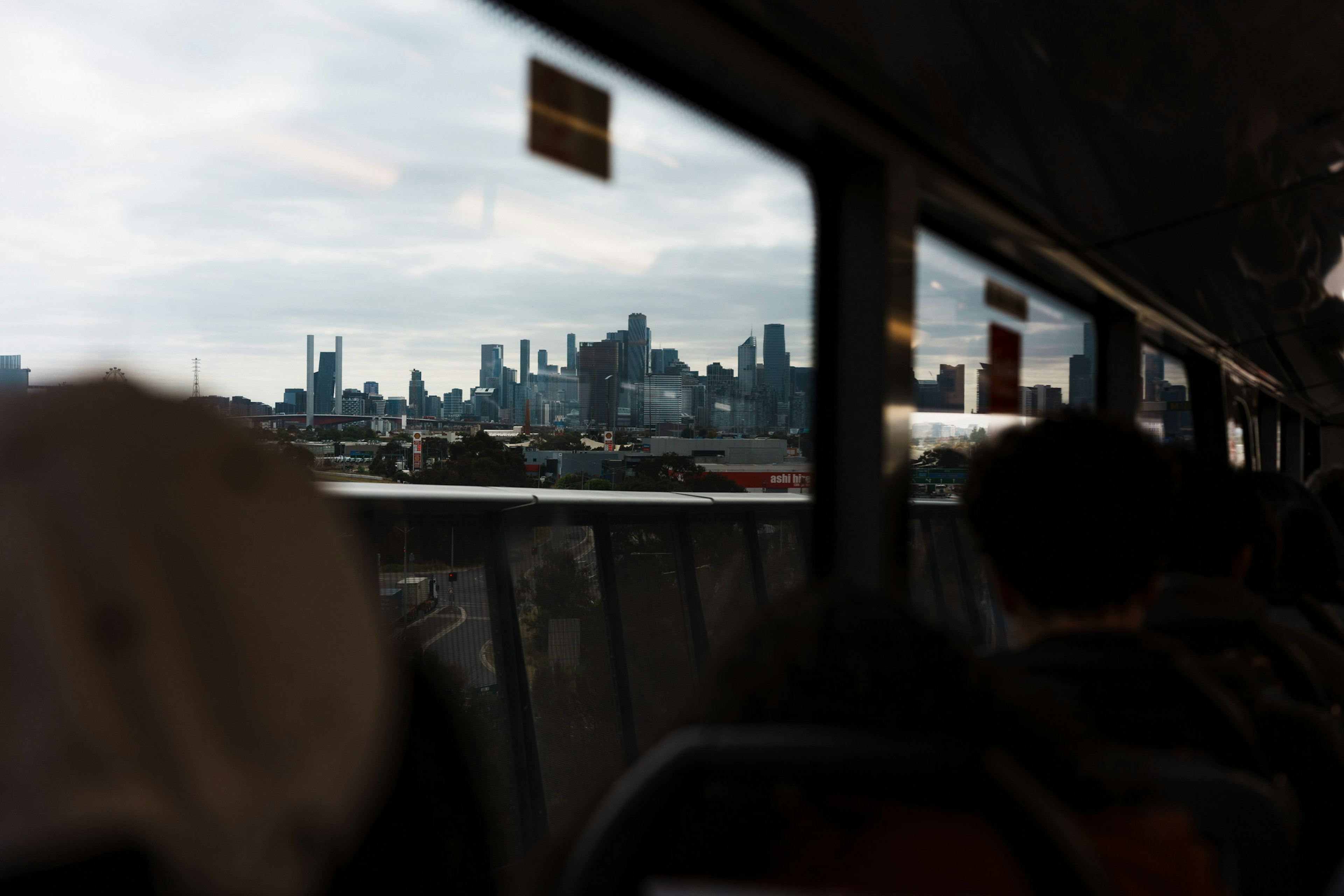 City skyline viewed from a bus window with cloudy sky