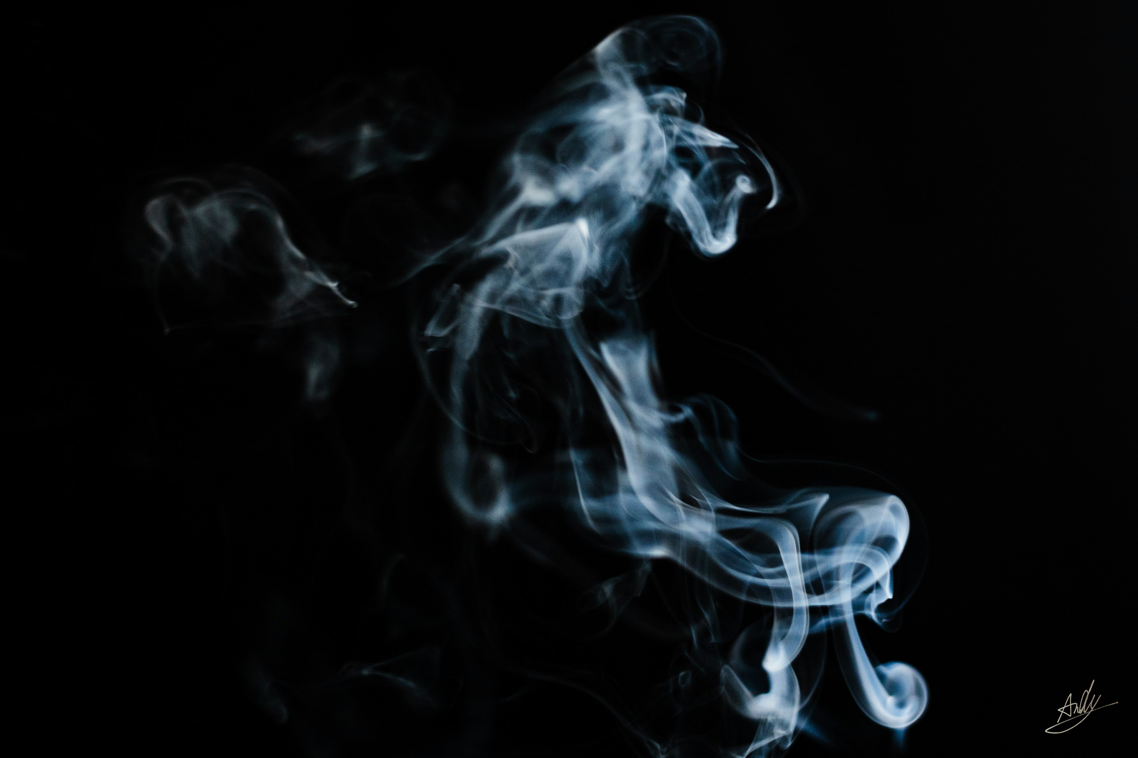 Artistic depiction of white-blue smoke against a black background