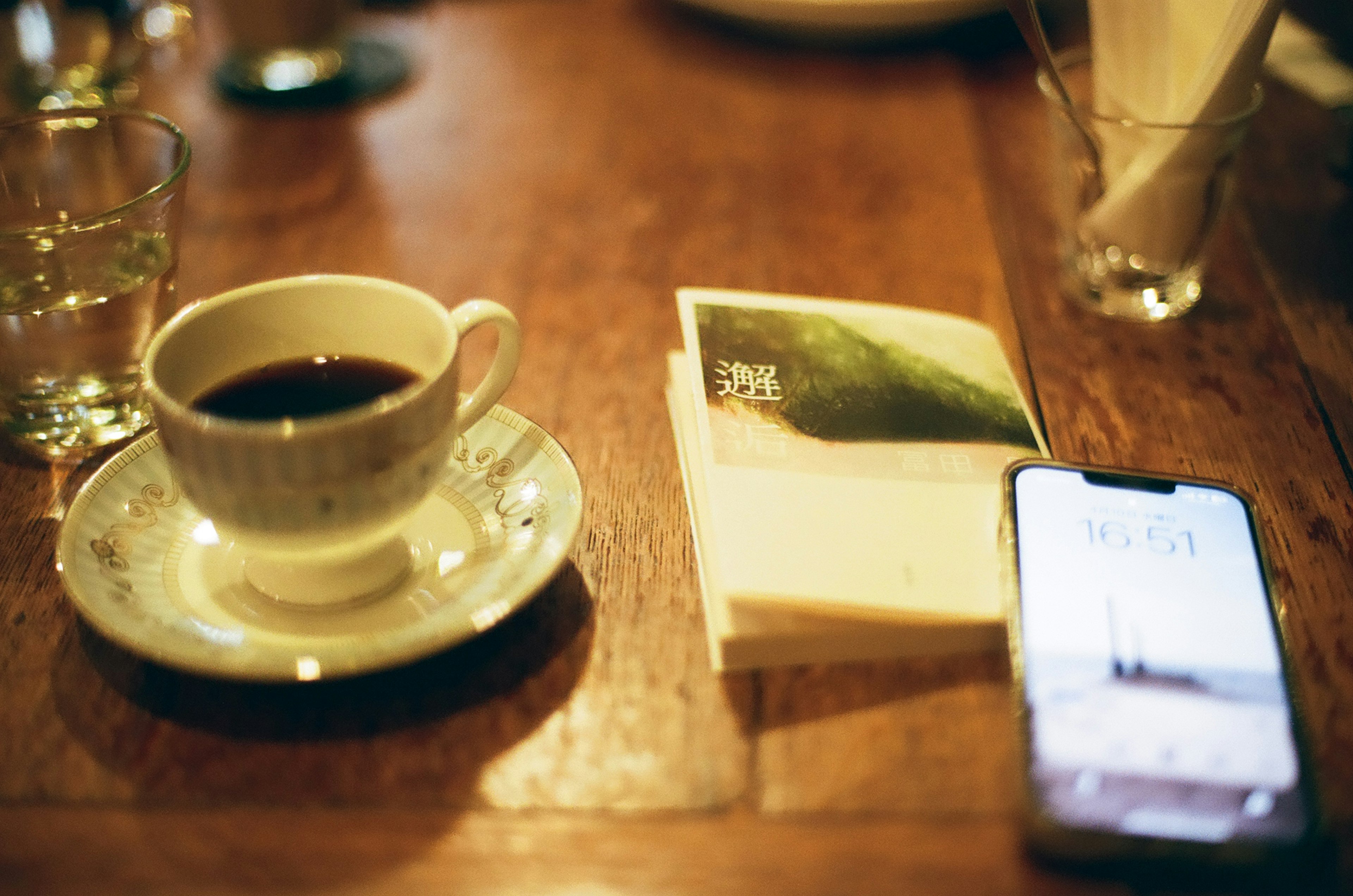 Coffee cup on a table with a book and a smartphone