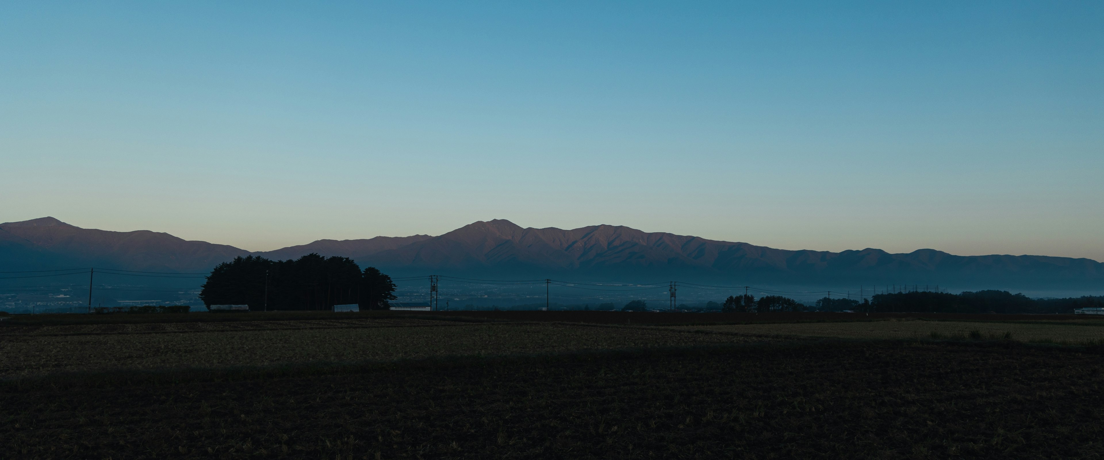 Silhouette of mountains against a blue sky at dawn