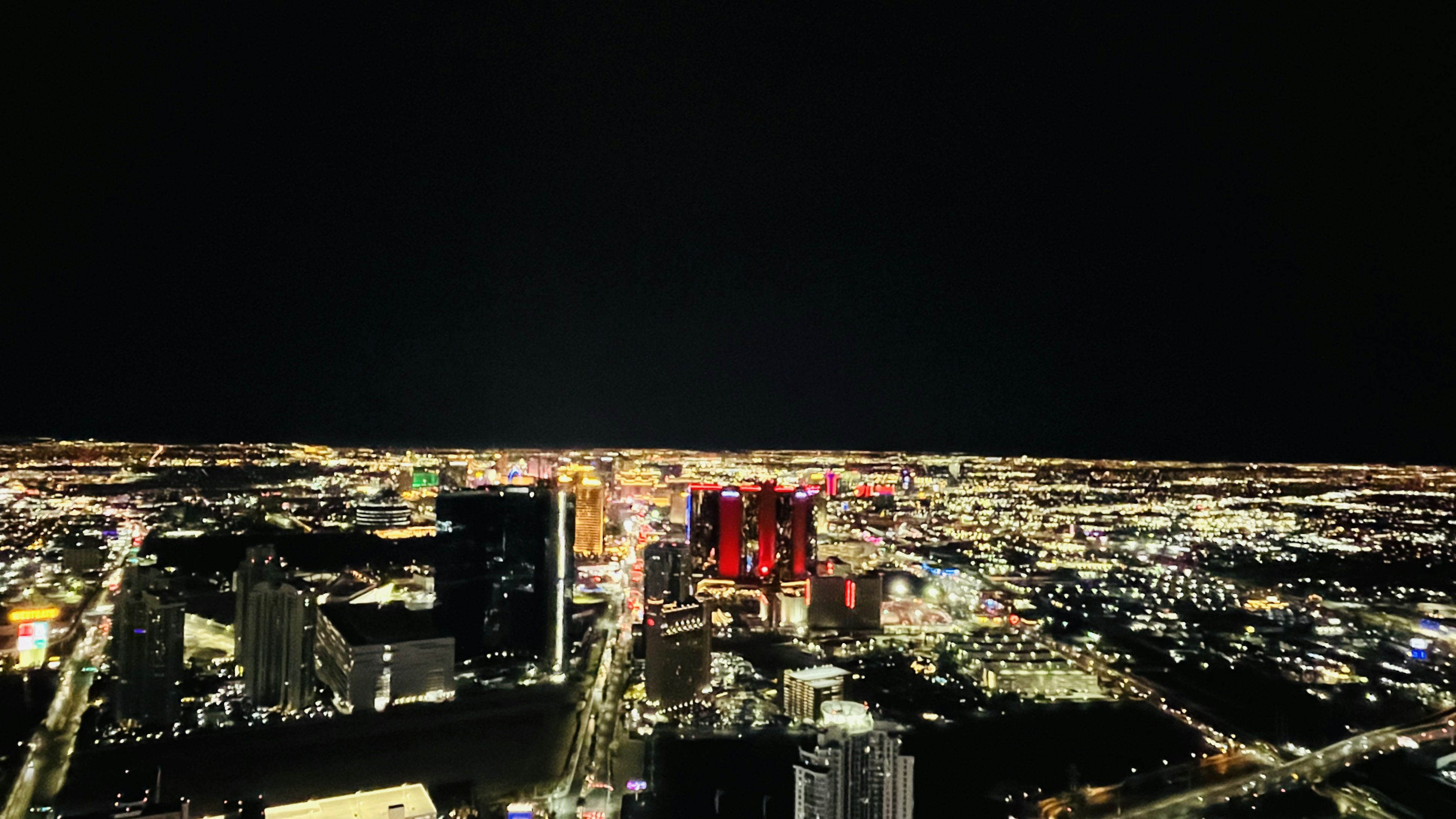 A nighttime city skyline with bright buildings and streetlights shining