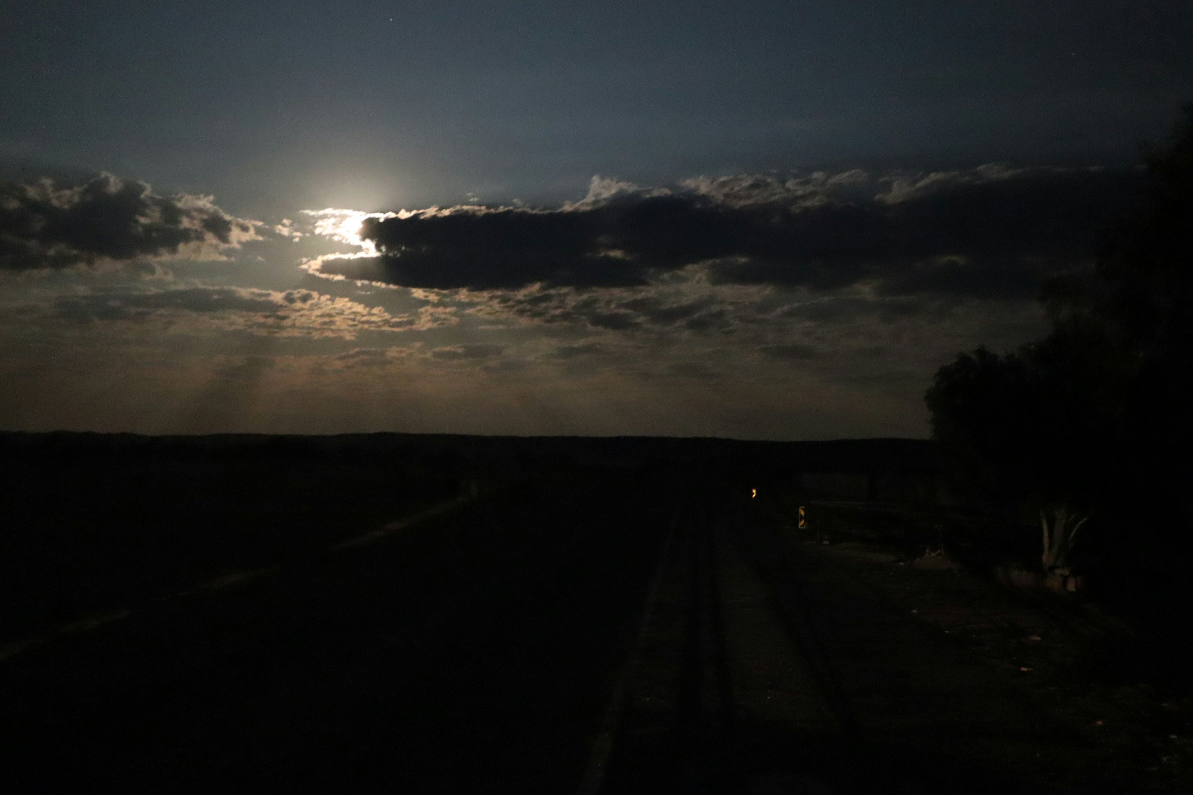 Paisaje con nubes y luz de luna en un cielo oscuro