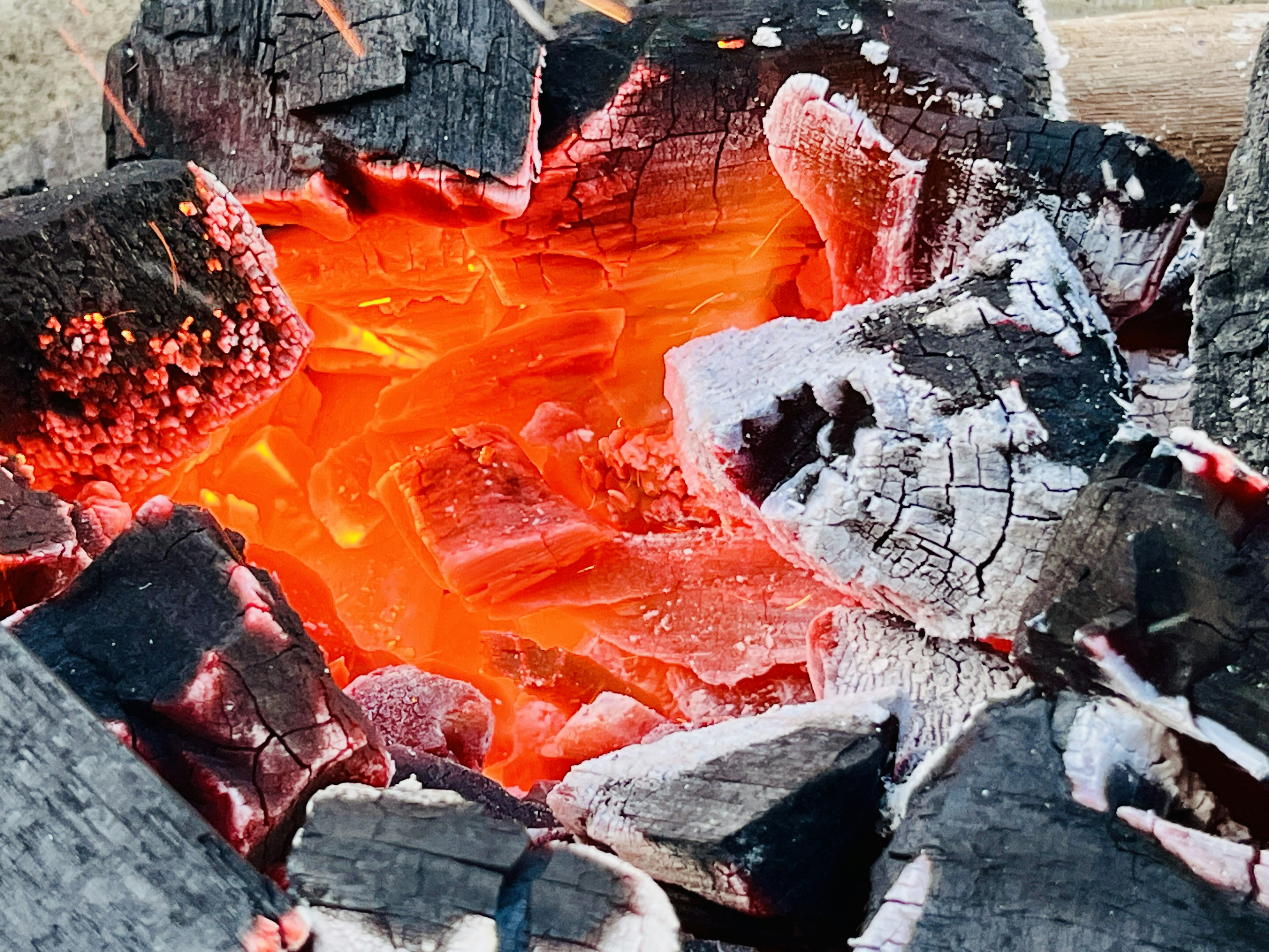 Glowing embers and ash with bright orange flames