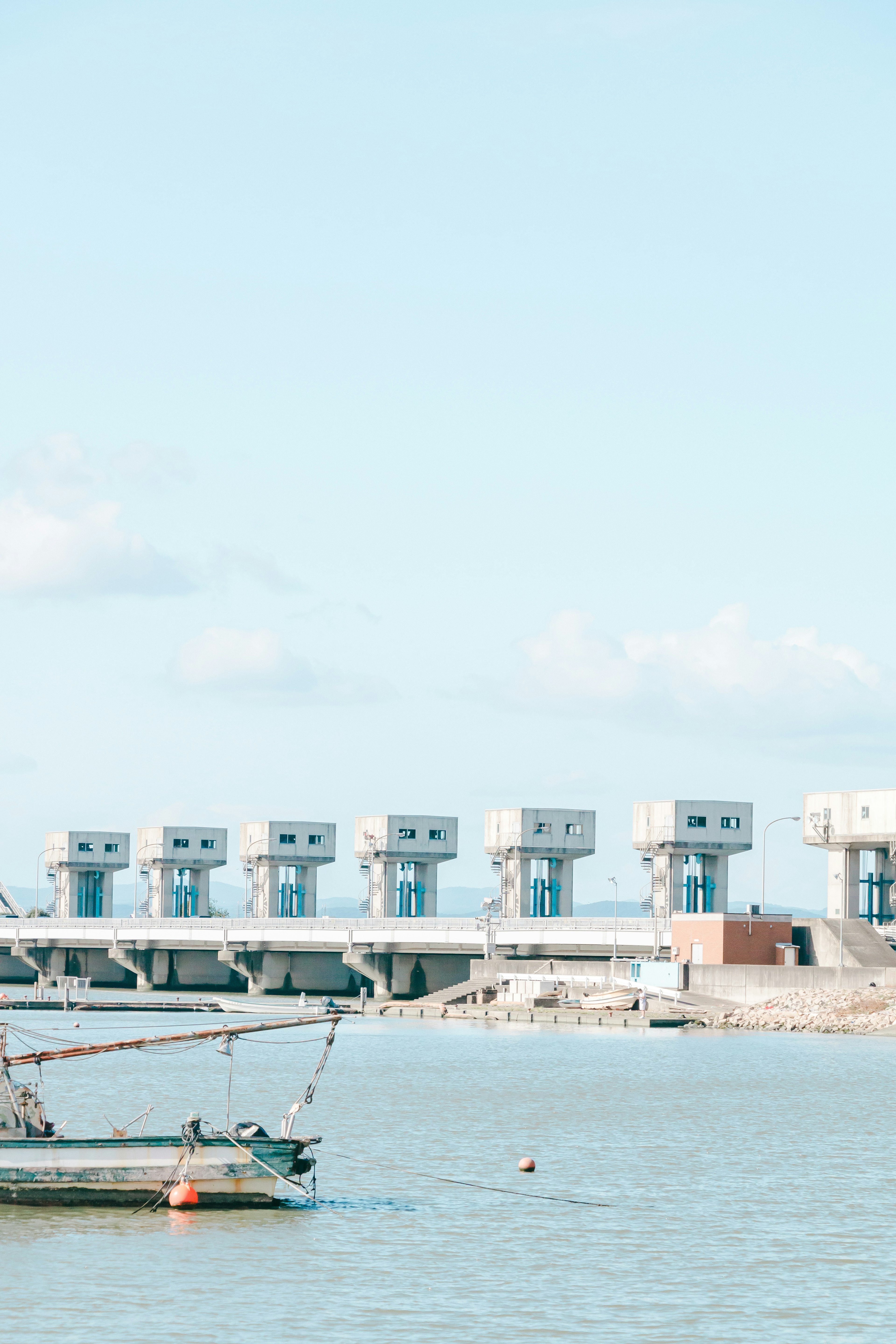 Petit bateau sur l'eau avec une structure de centrale électrique en arrière-plan