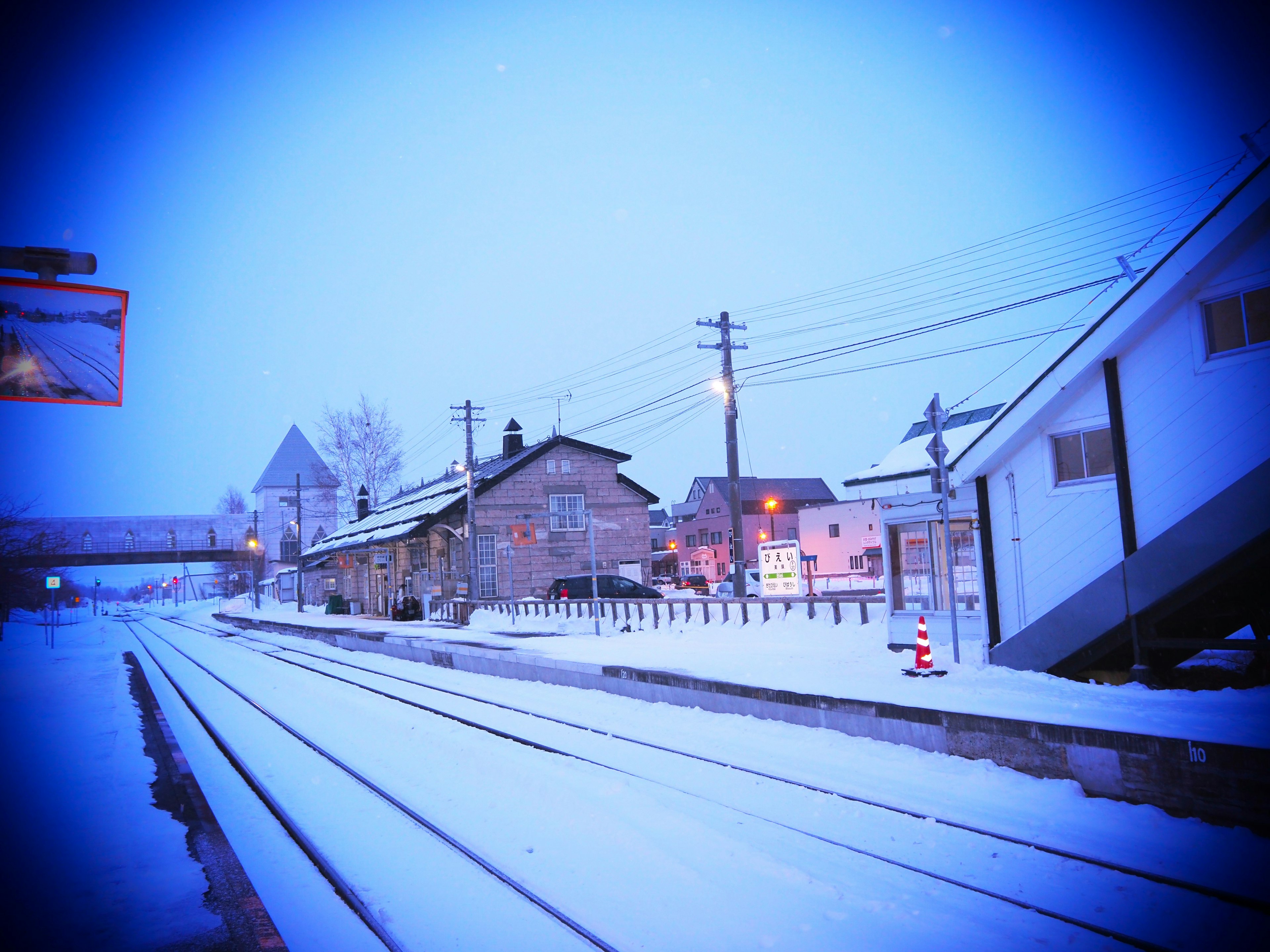 雪に覆われた駅の風景 鉄道の線路と家屋が見える