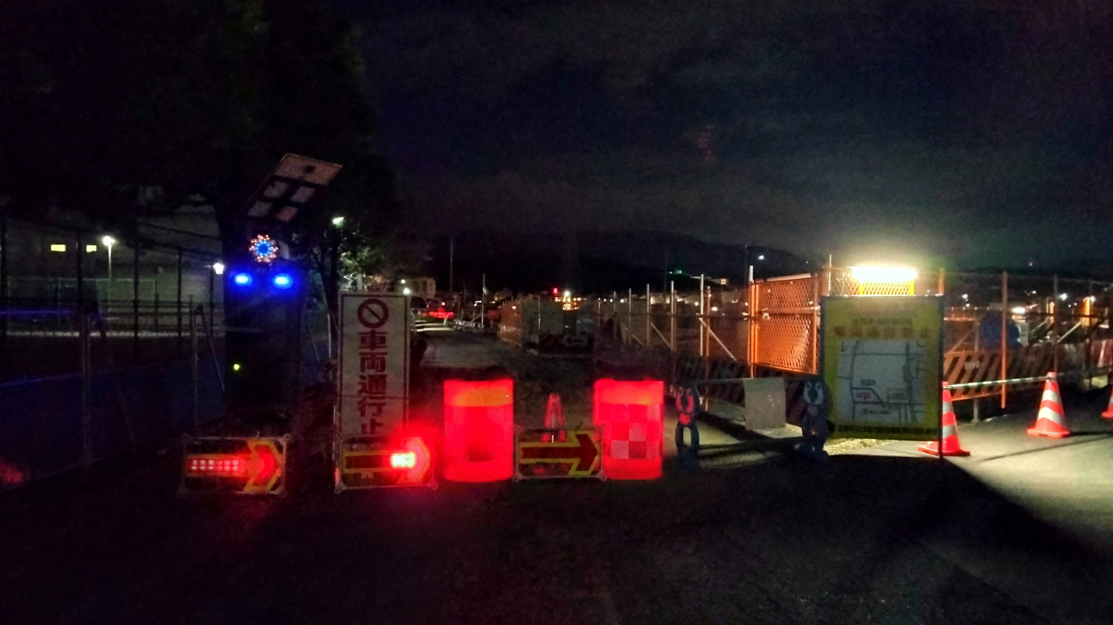 Red barricade and yellow lighting at a construction site at night