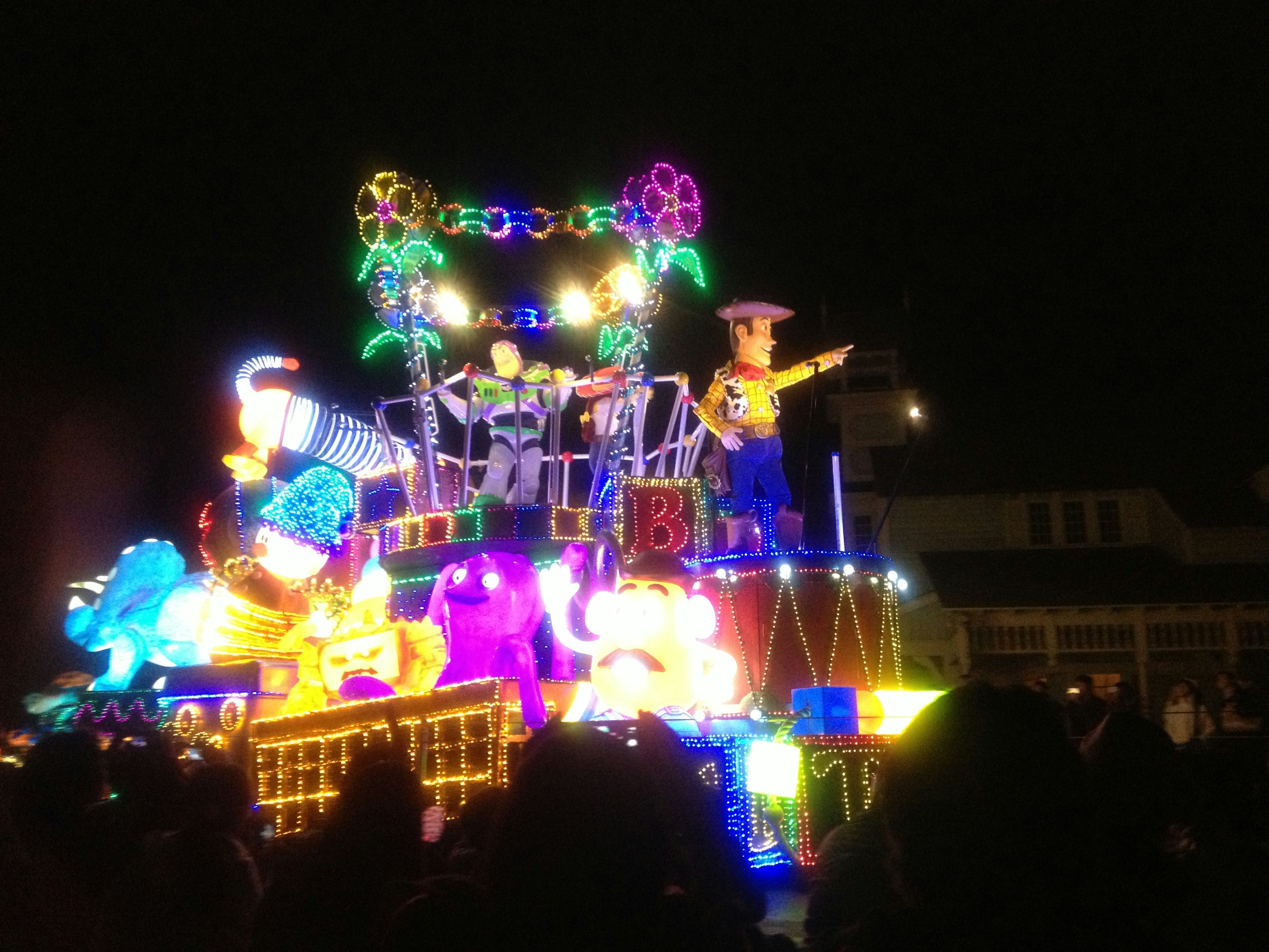 Float de desfile iluminado y colorido con animales y artistas de noche