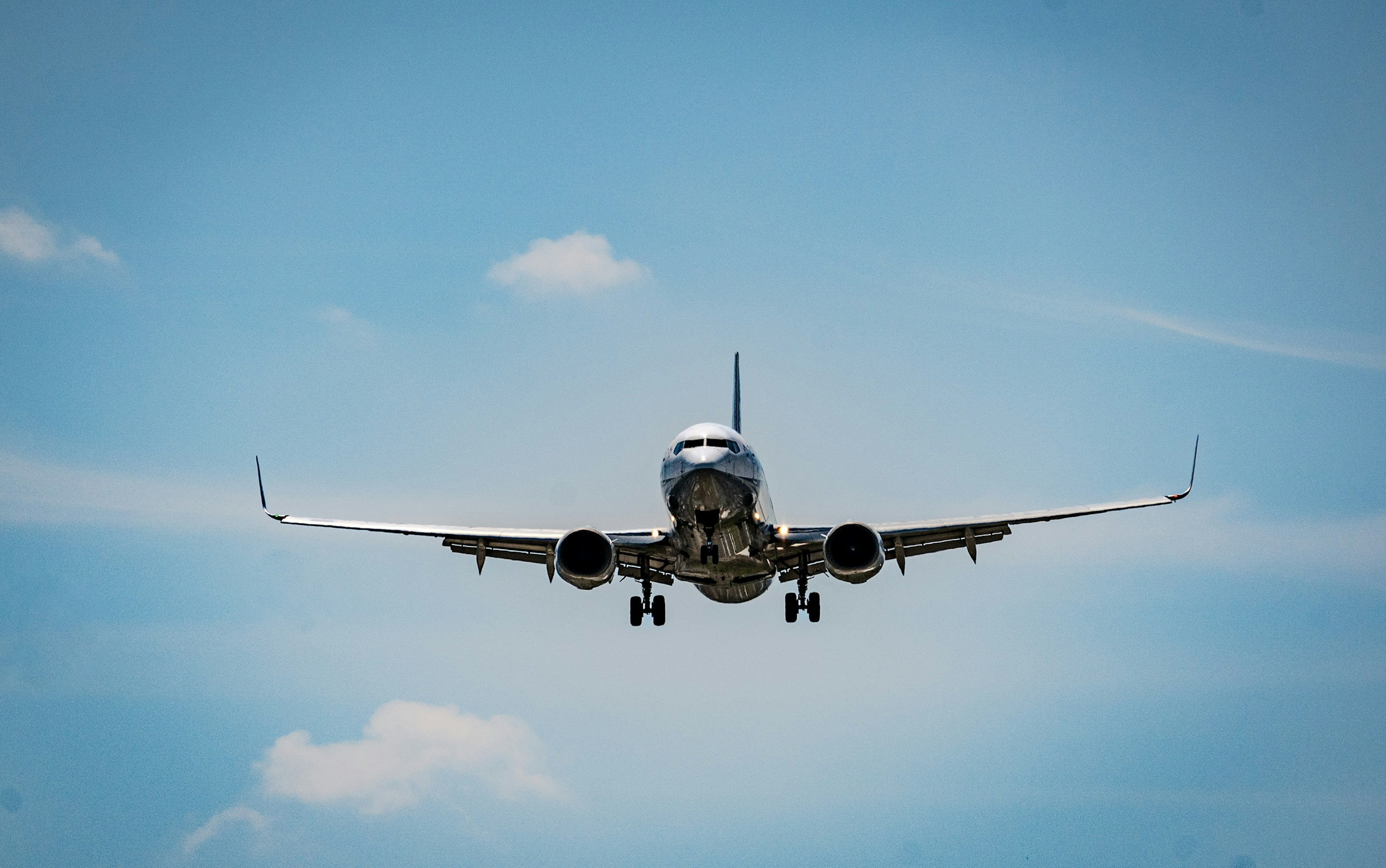 An airplane gliding against a blue sky