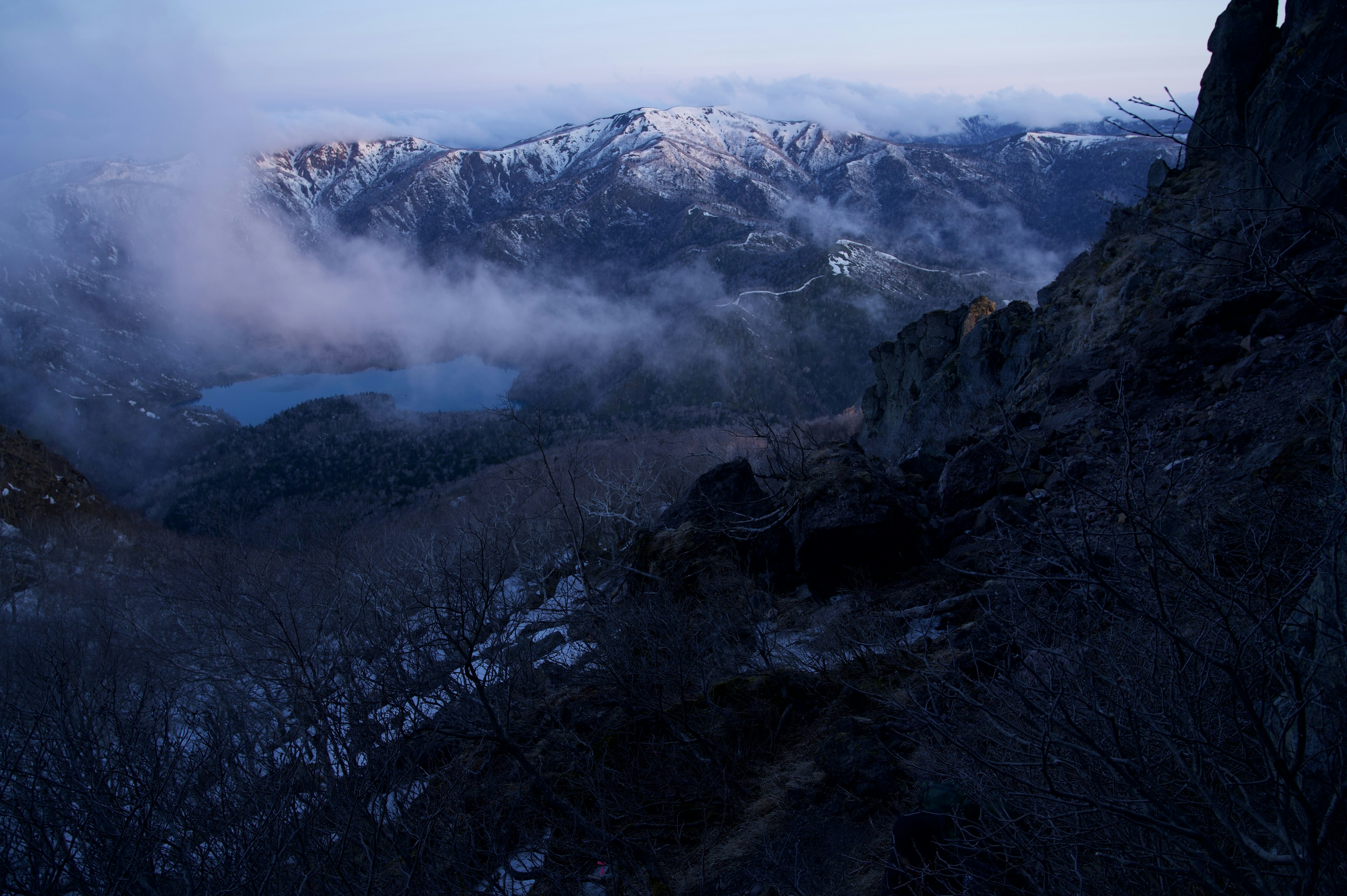 Berglandschaft in Nebel gehüllt mit einem blauen See