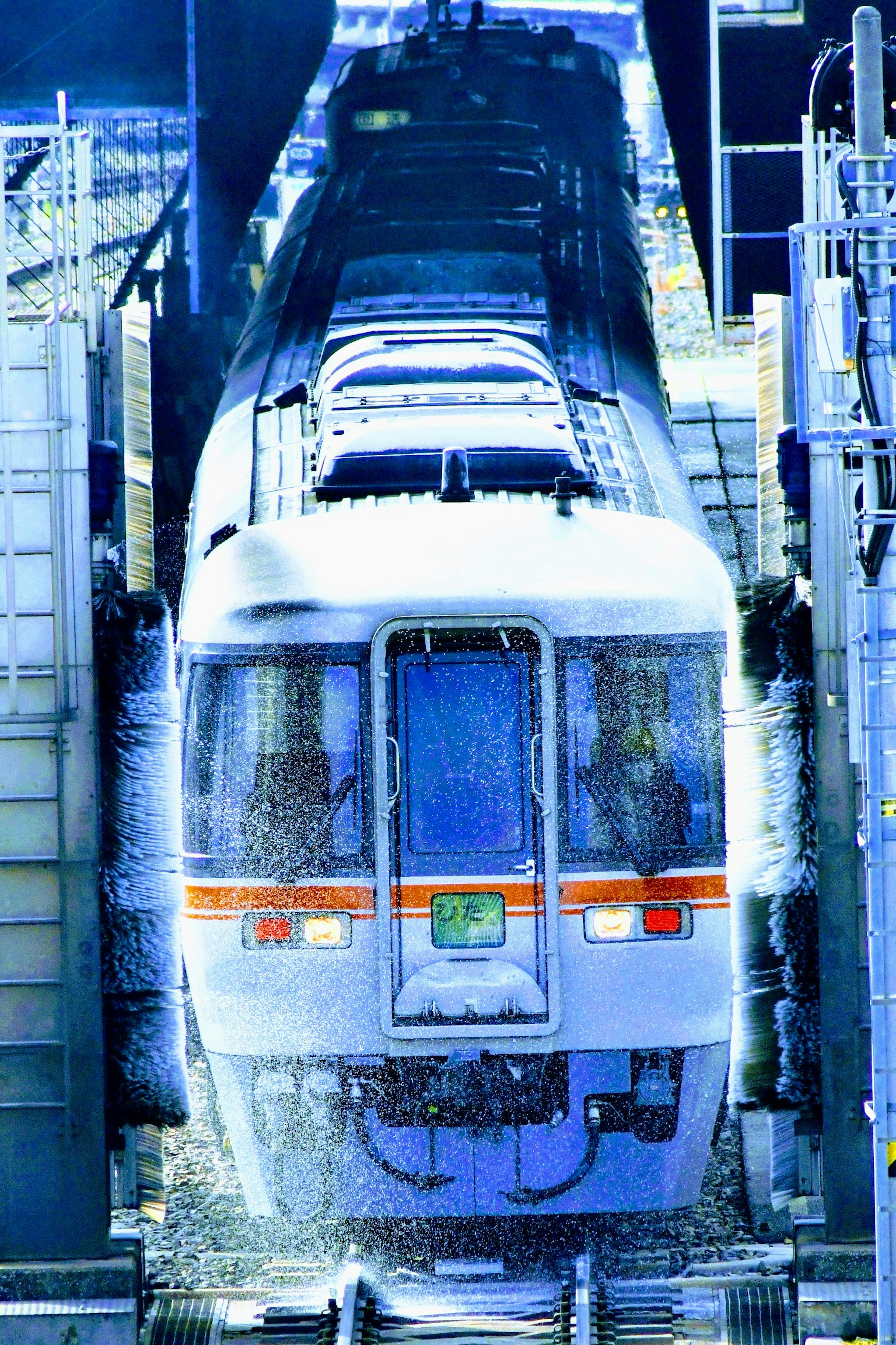 Train emerging from snow with a blue-toned background conveying coldness