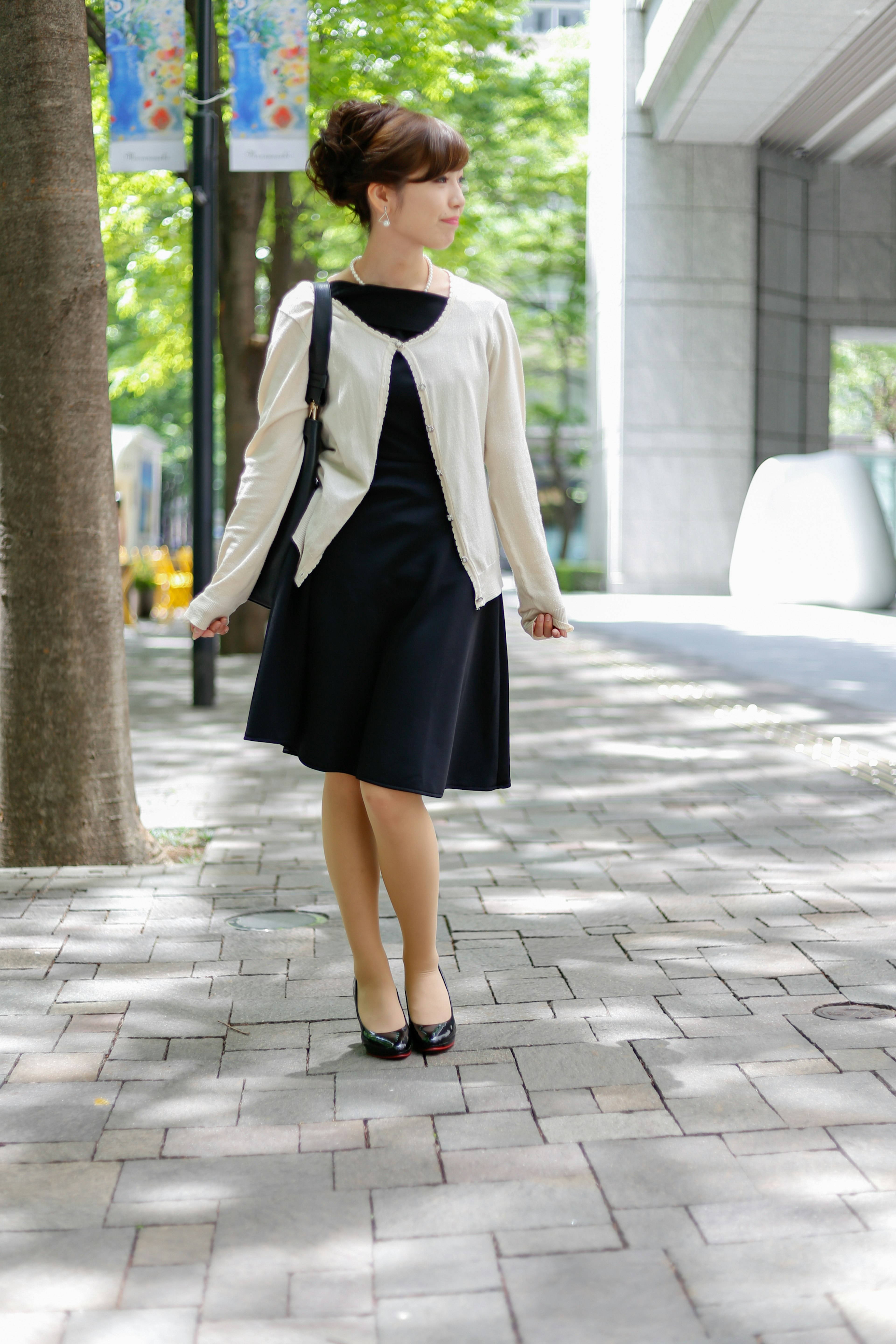 Mujer con vestido negro caminando en la ciudad