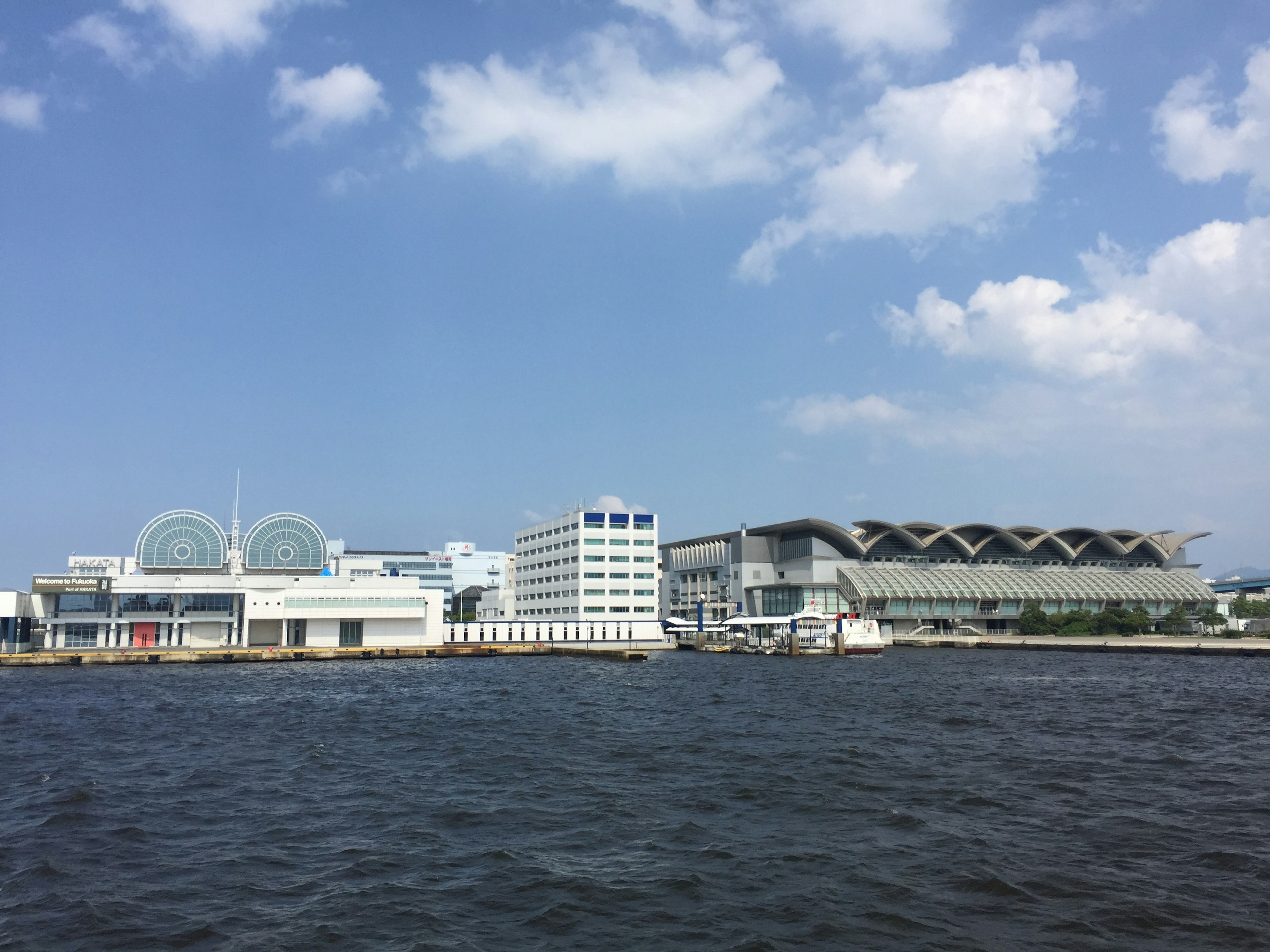 Modern buildings along the waterfront under a blue sky