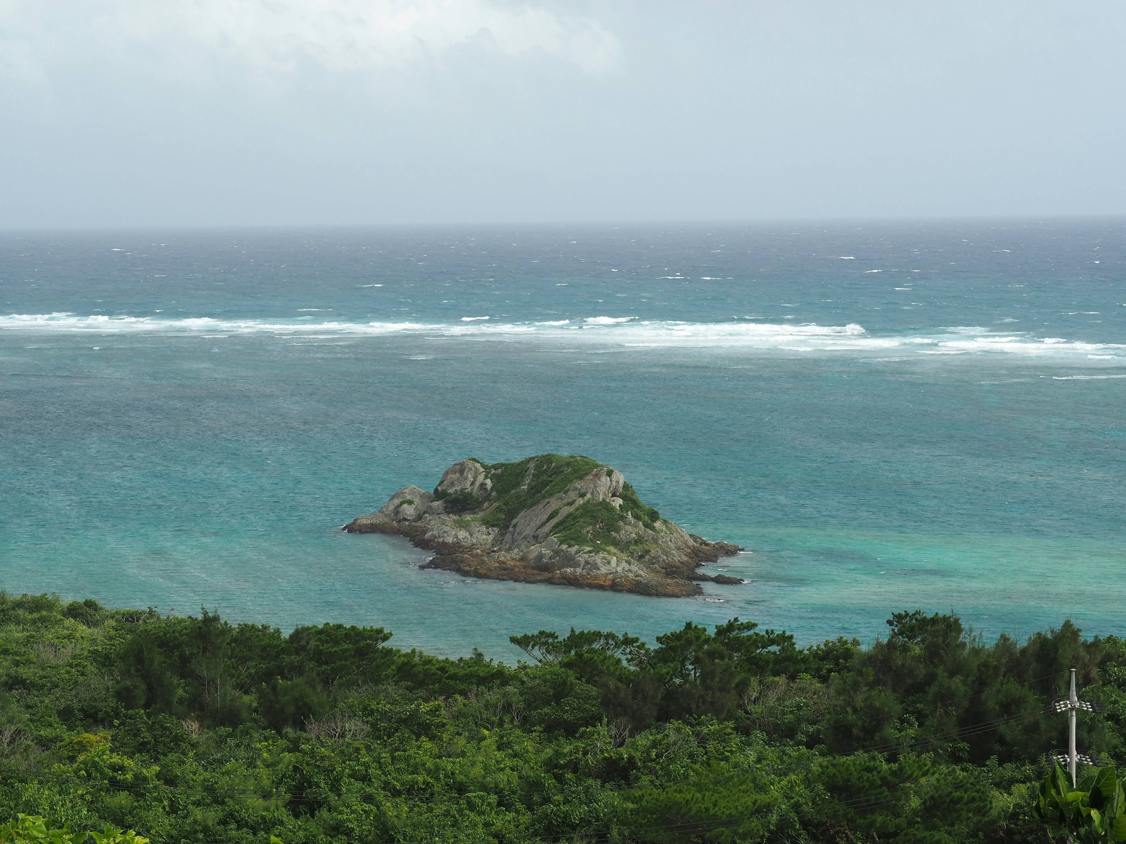 Vue pittoresque d'une petite île entourée par un océan bleu