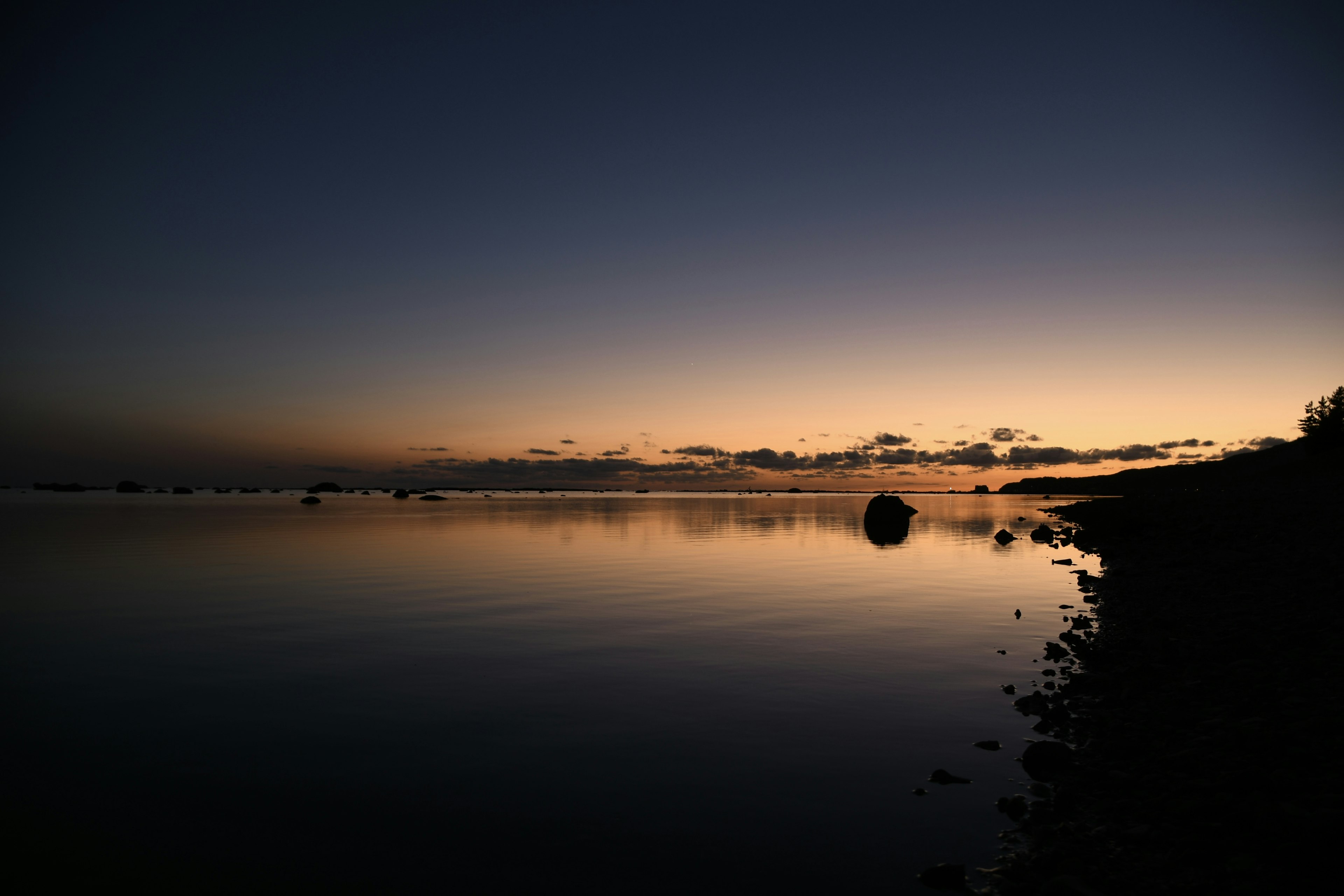 Paysage serein d'une mer au crépuscule se reflétant sur des eaux calmes