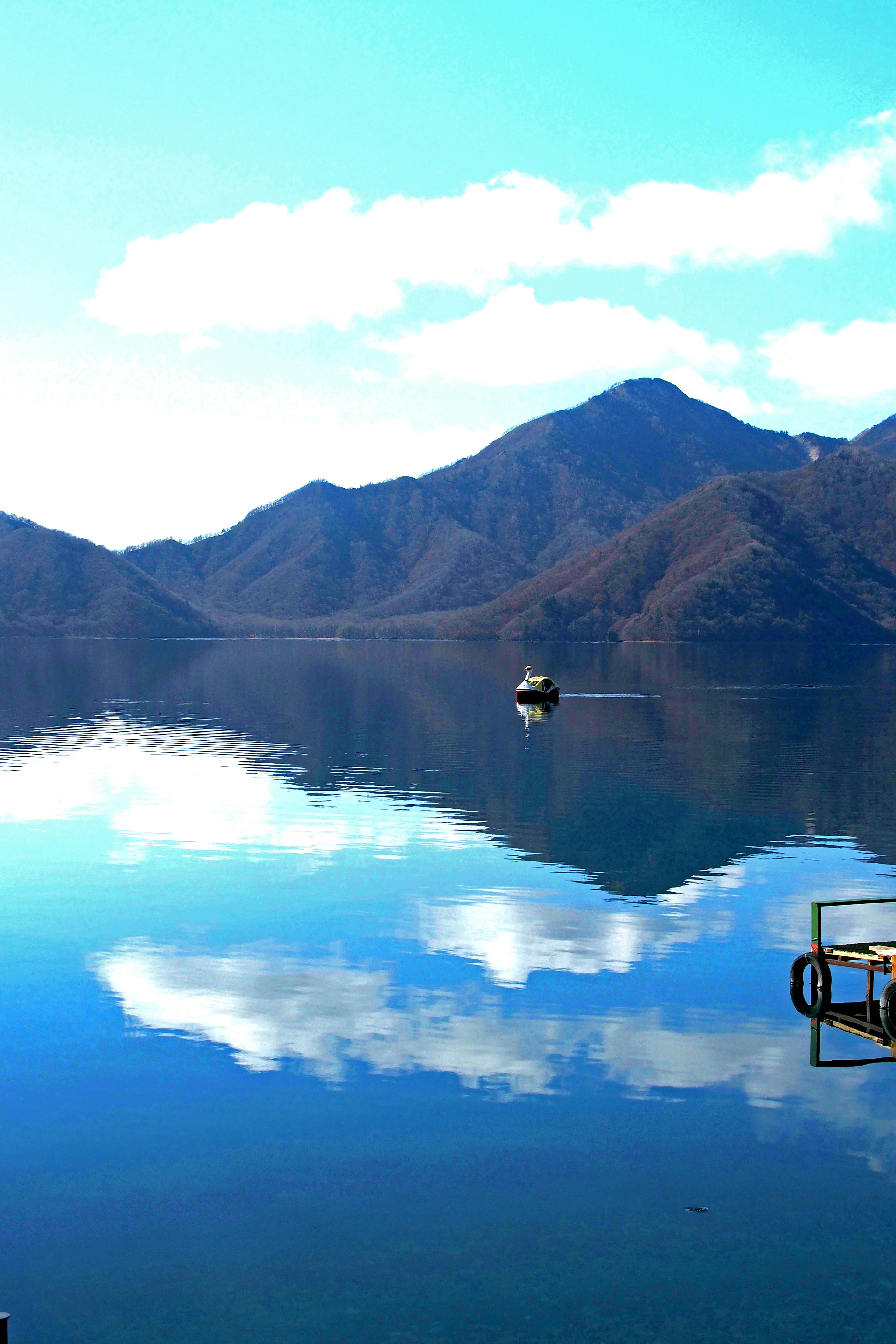 Serene lake reflecting mountains and clouds