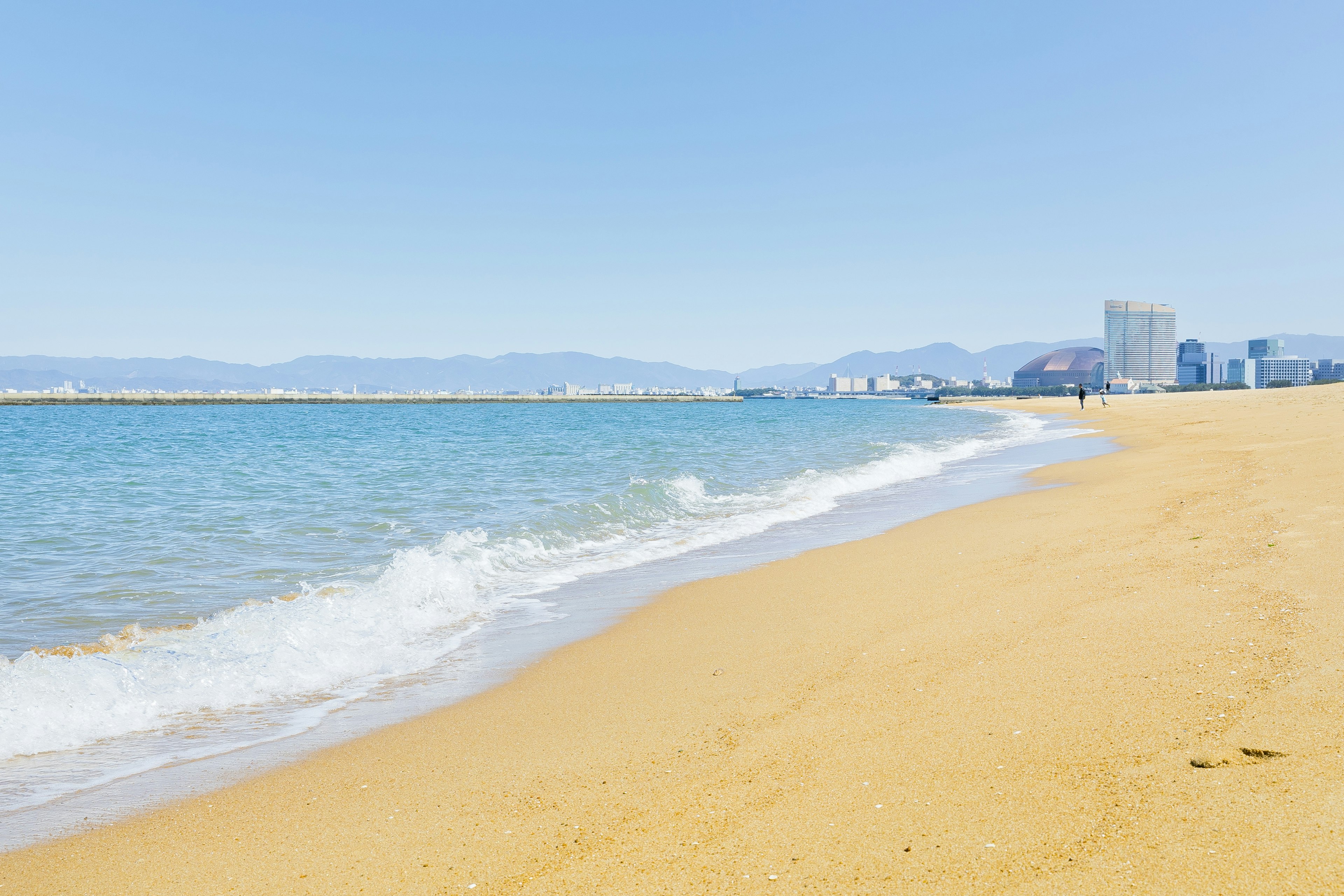 Eine malerische Strandansicht mit blauem Wasser und goldenem Sand