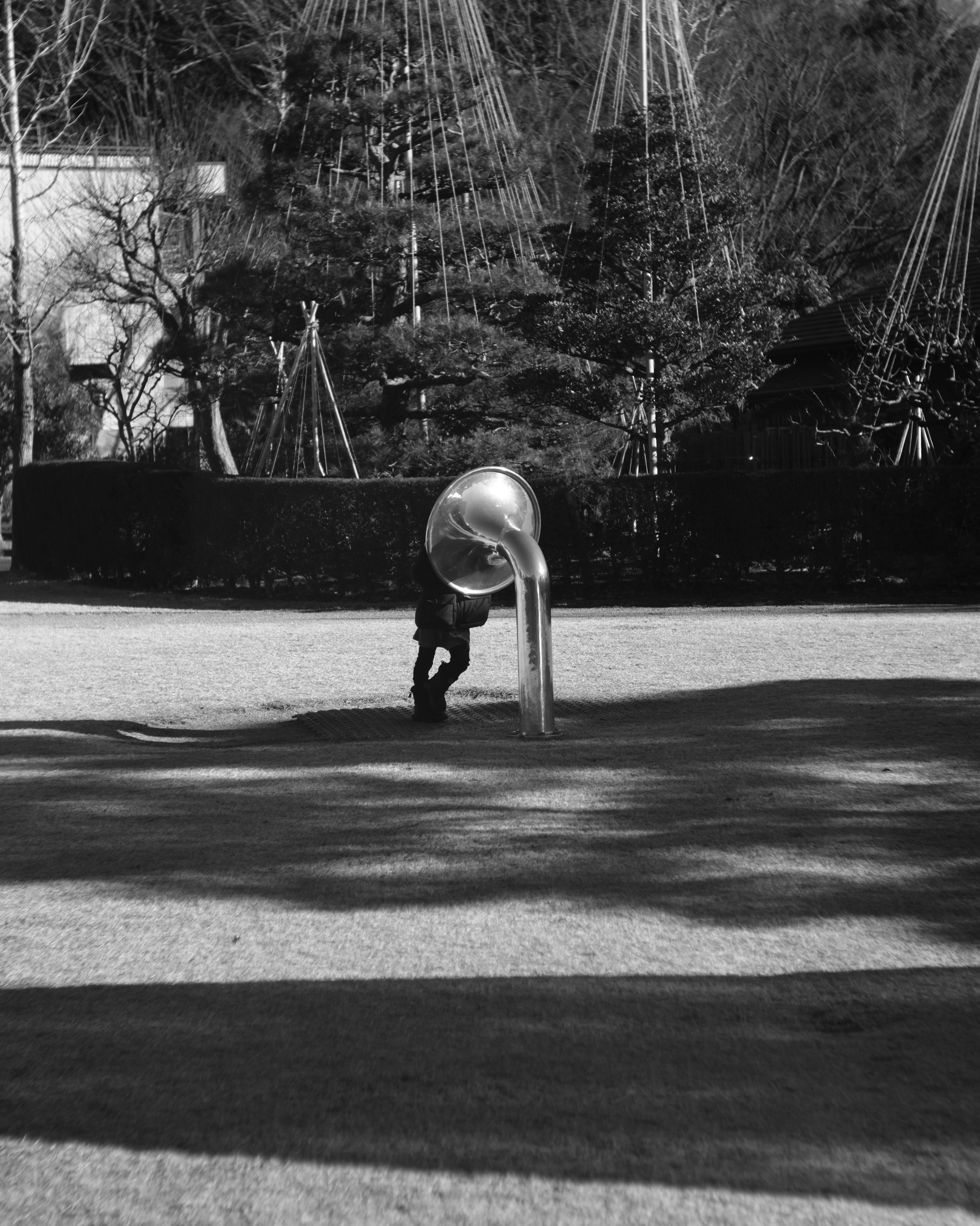 Niño jugando en un tobogán de metal en un parque