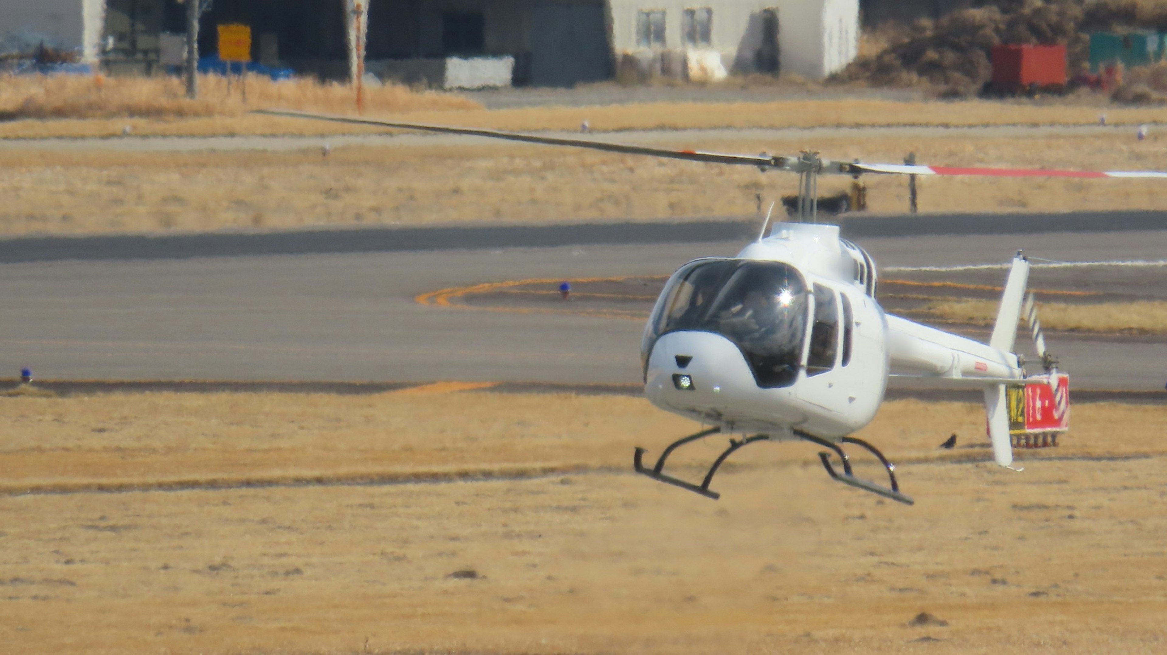 Un hélicoptère blanc atterrissant au sol