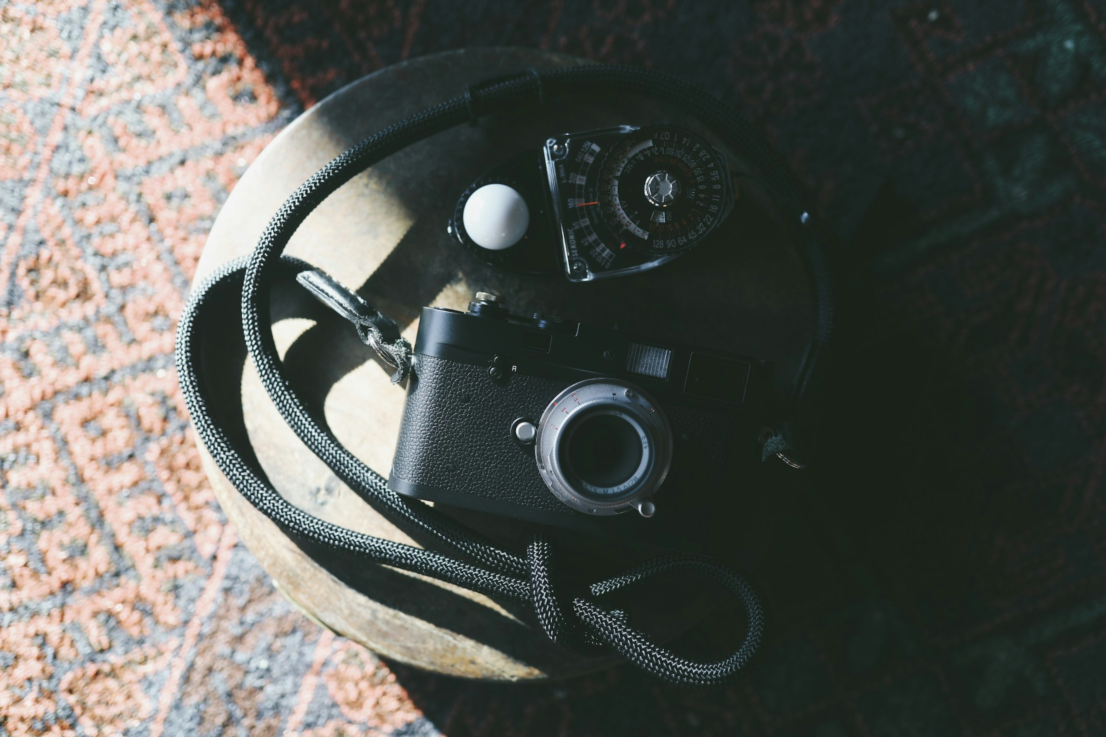 A vintage camera with a lens and accessories on a textured surface