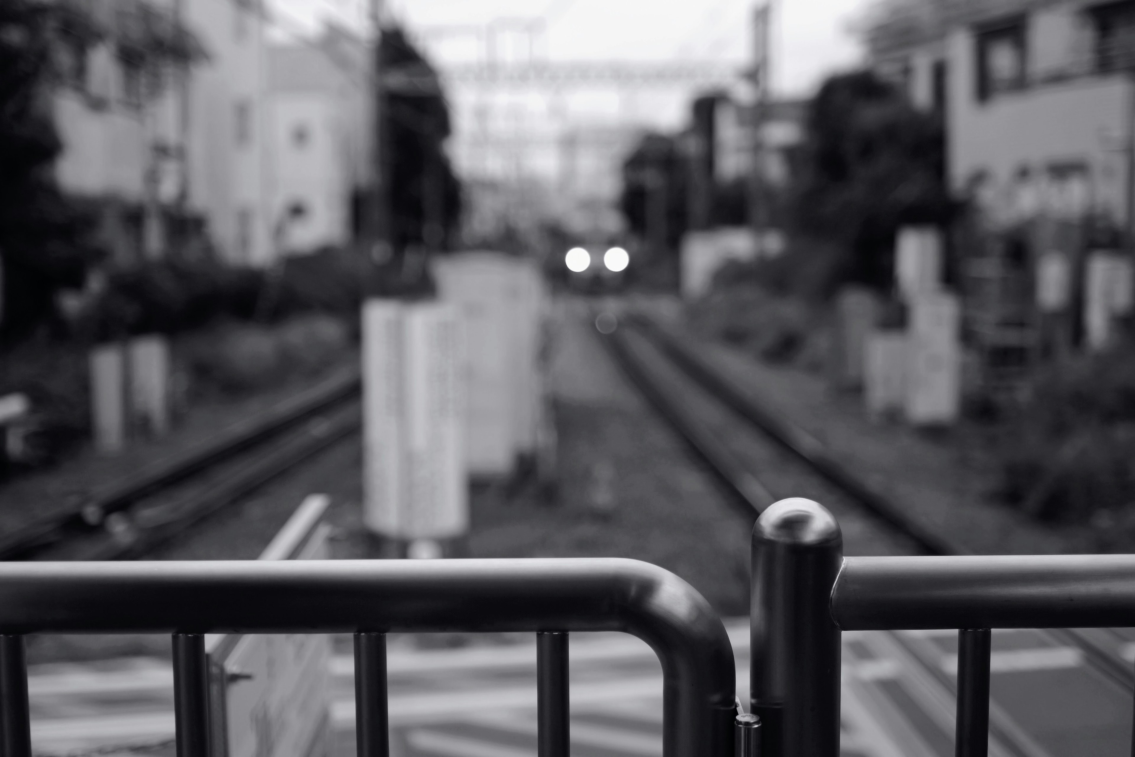 ภาพมุมมองเบลอของรางรถไฟและประตูในทิวทัศน์ขาวดำ