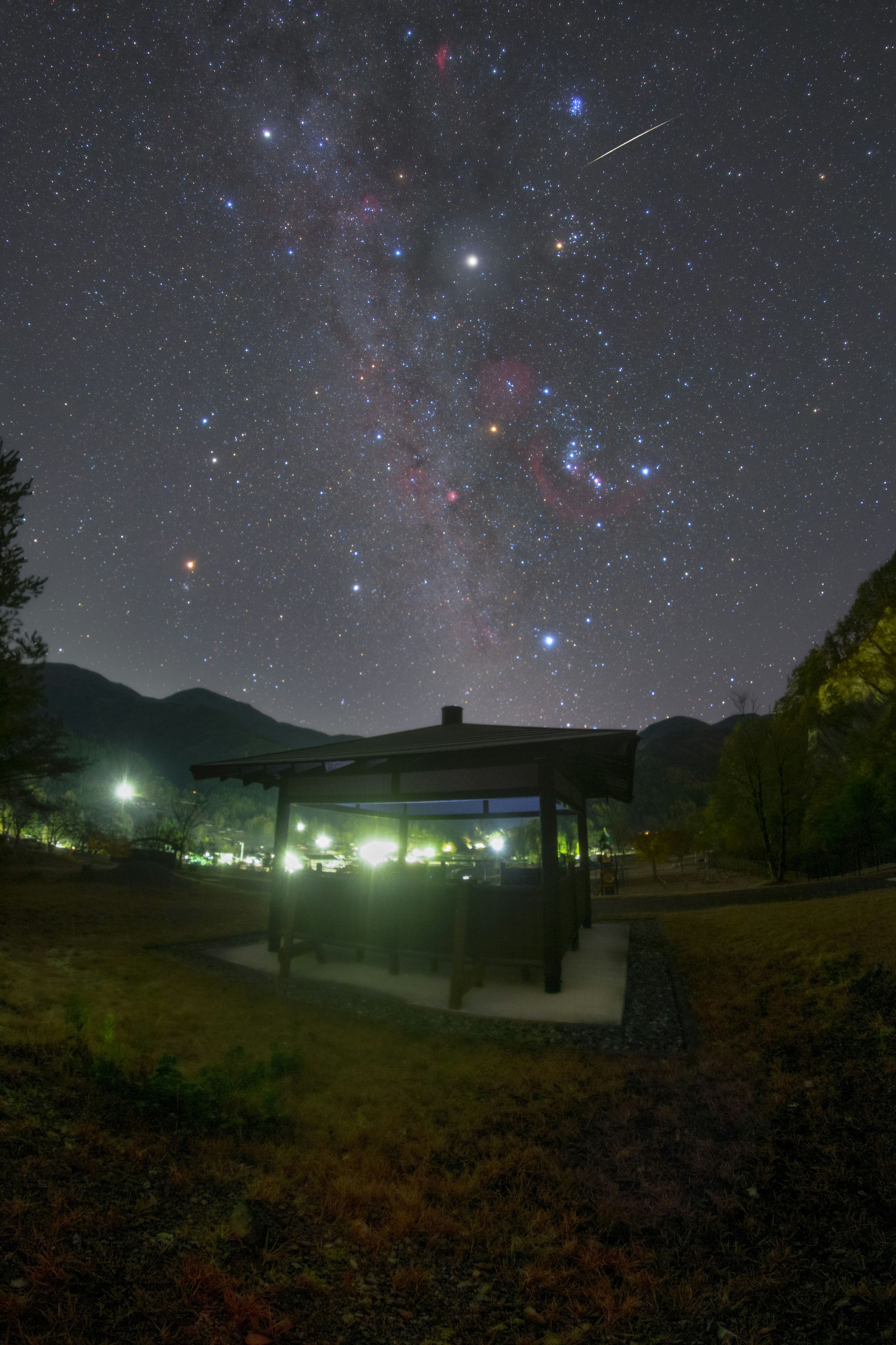 星空の下にある小屋と山々の風景