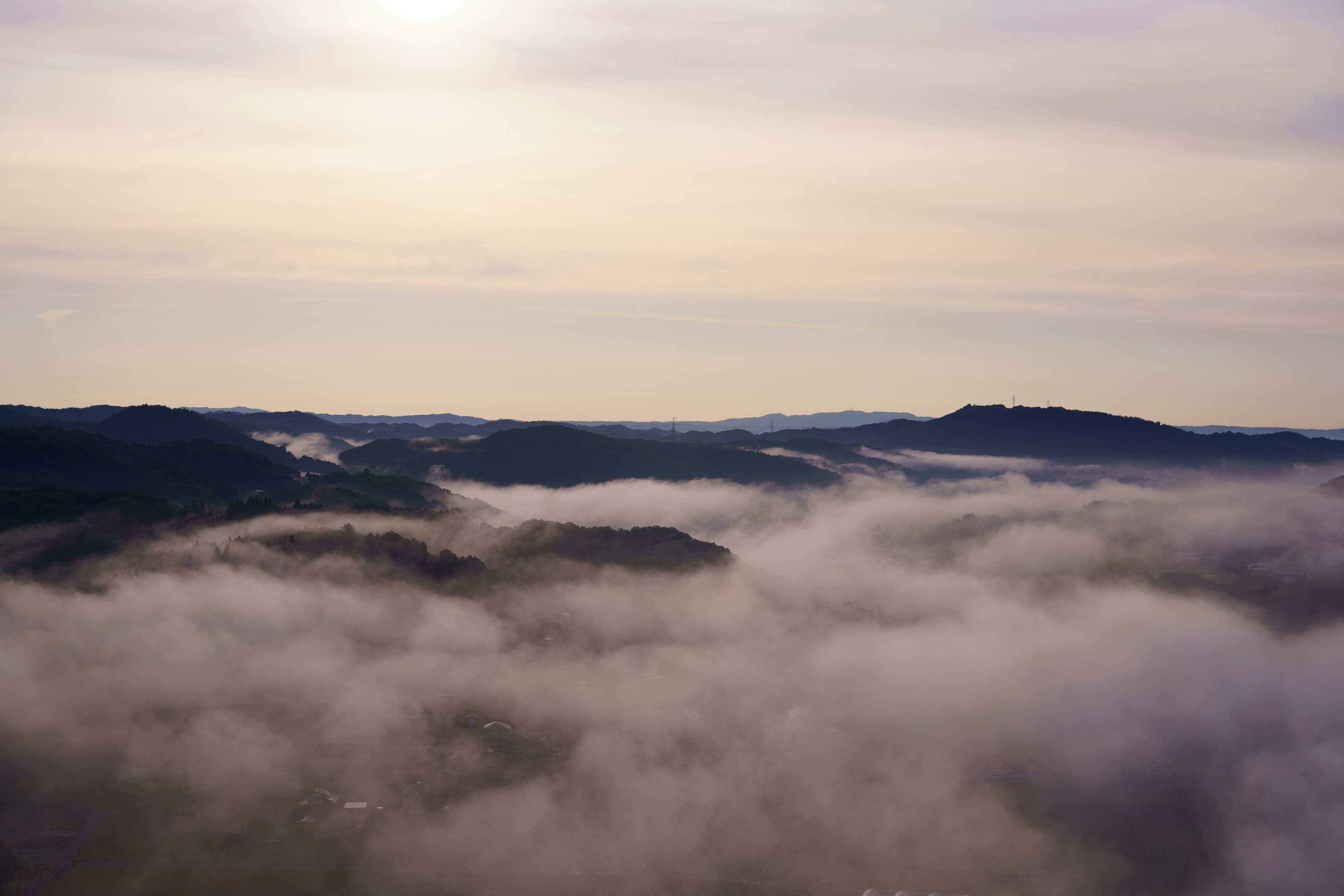 霧に包まれた山々と柔らかな光が差し込む風景