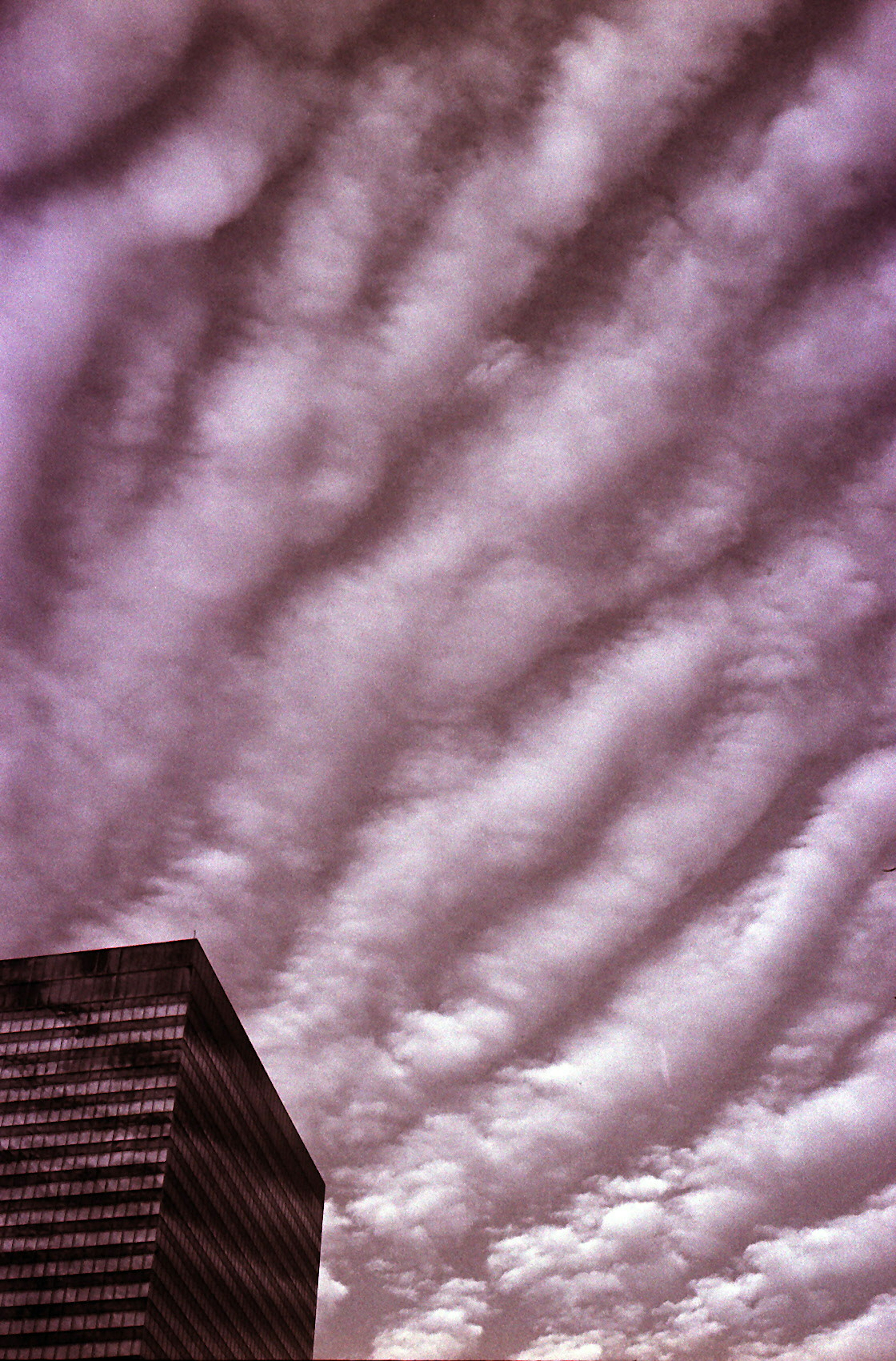 Sky with wavy clouds and the side of a modern building