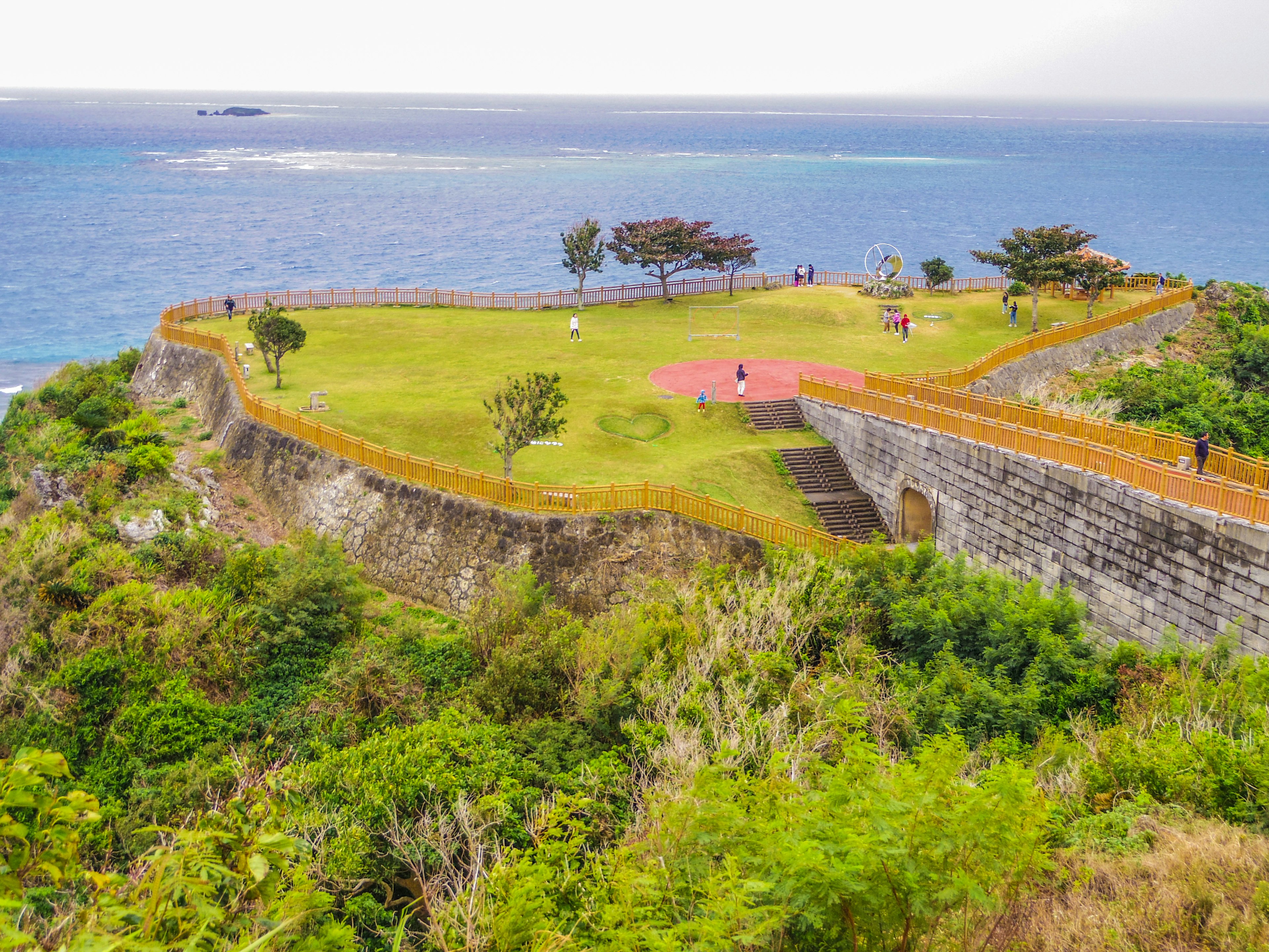 海に囲まれた緑豊かな丘の上にある歴史的な要塞の風景