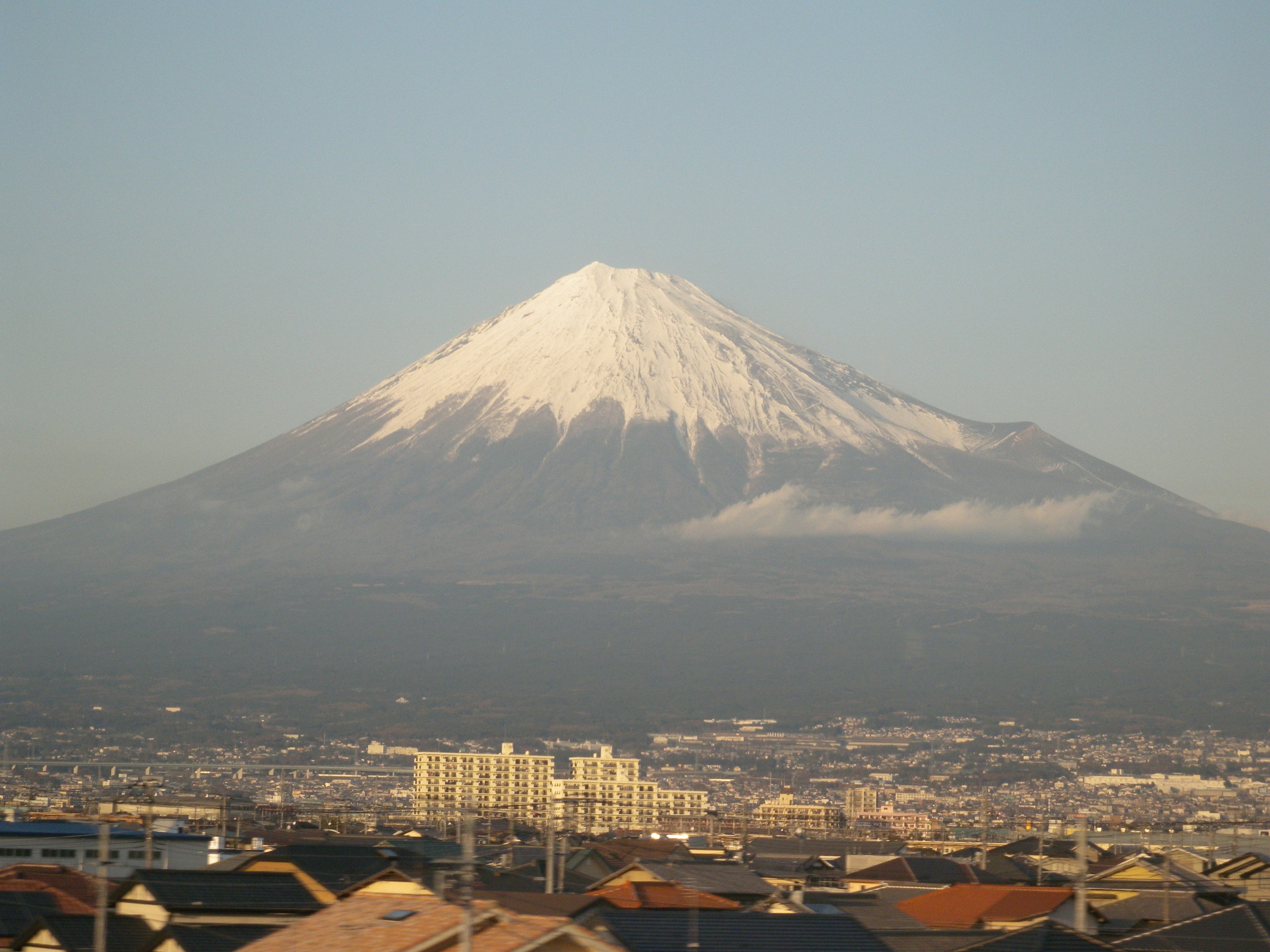 Cima innevata del Monte Fuji con paesaggio urbano circostante