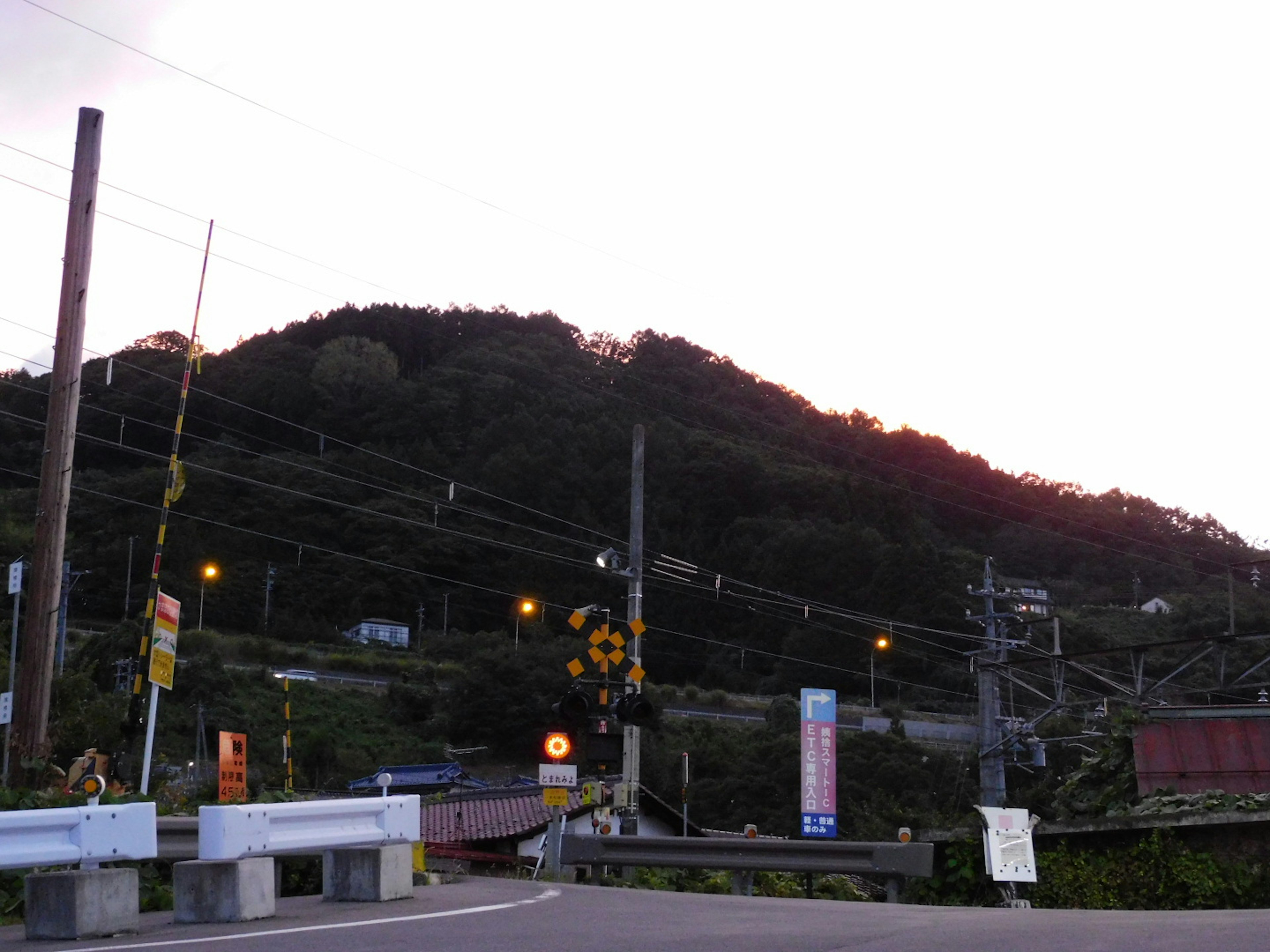 黃昏時分的山景與道路交叉口及電線杆的風景