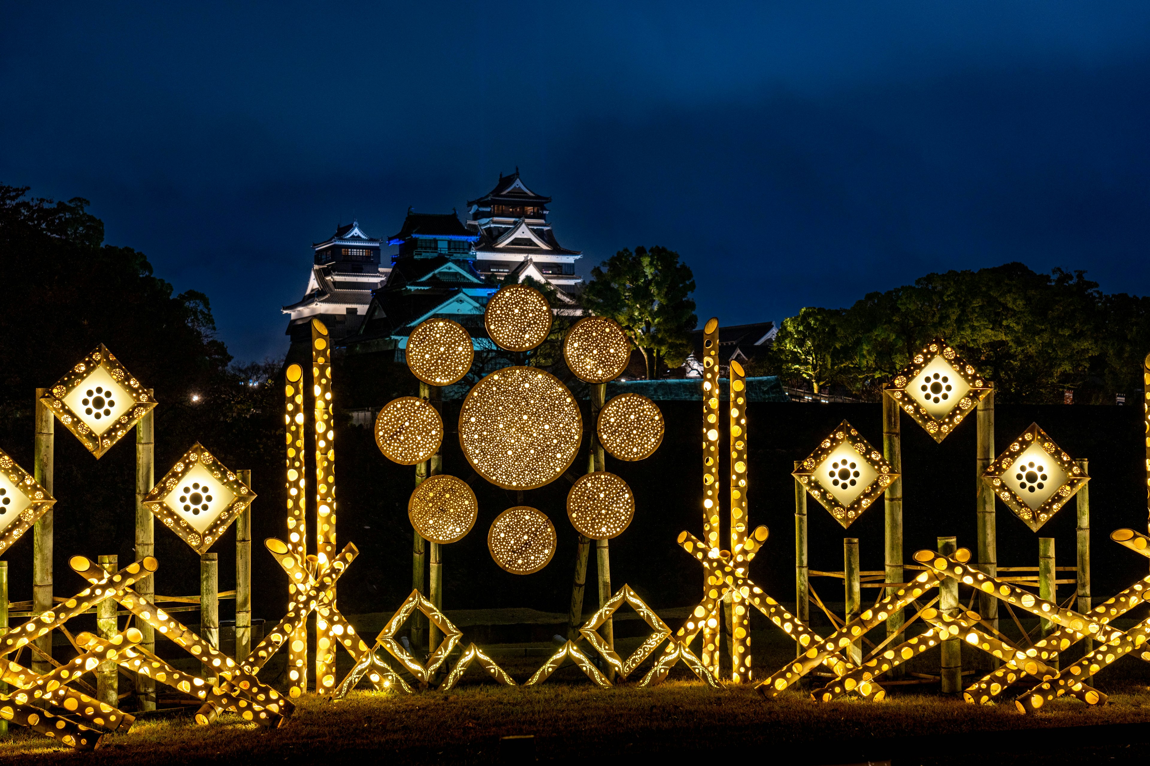 Arco decorativo iluminado con un castillo de fondo por la noche