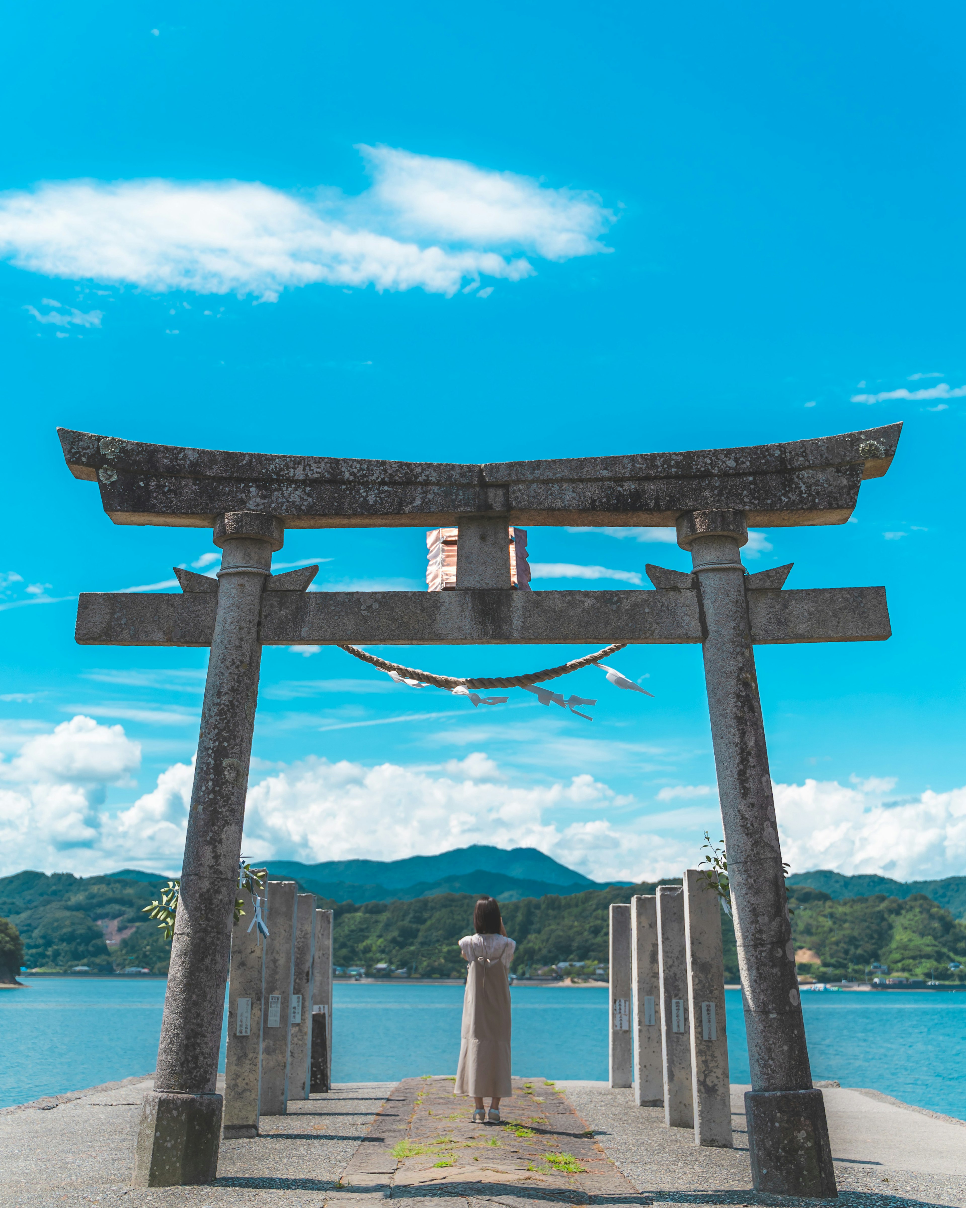 青い空の下にある神社の鳥居と海の景色