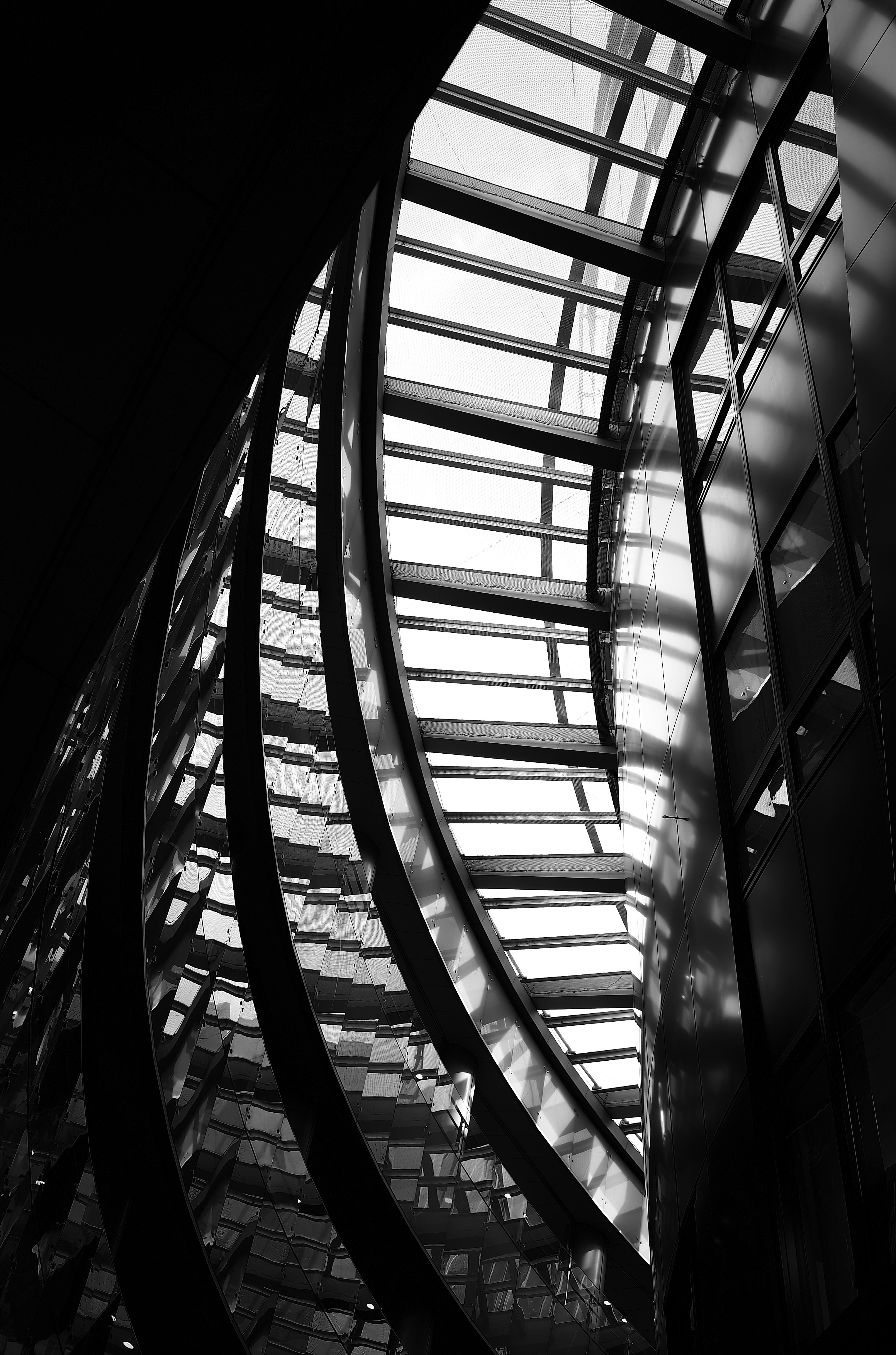 Interior of a building featuring curved glass structure and light contrast