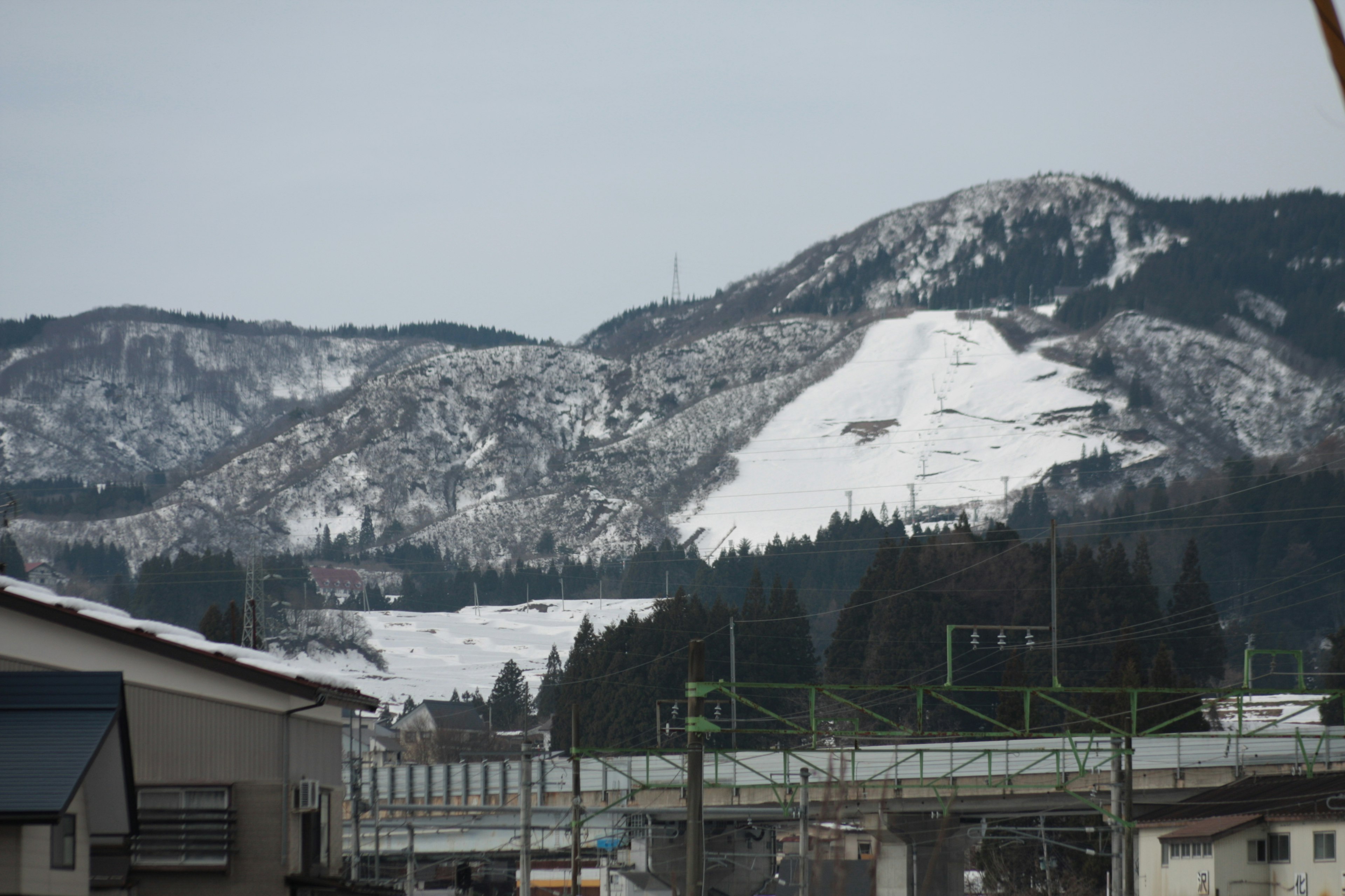 Montagne innevate con binari del treno in primo piano