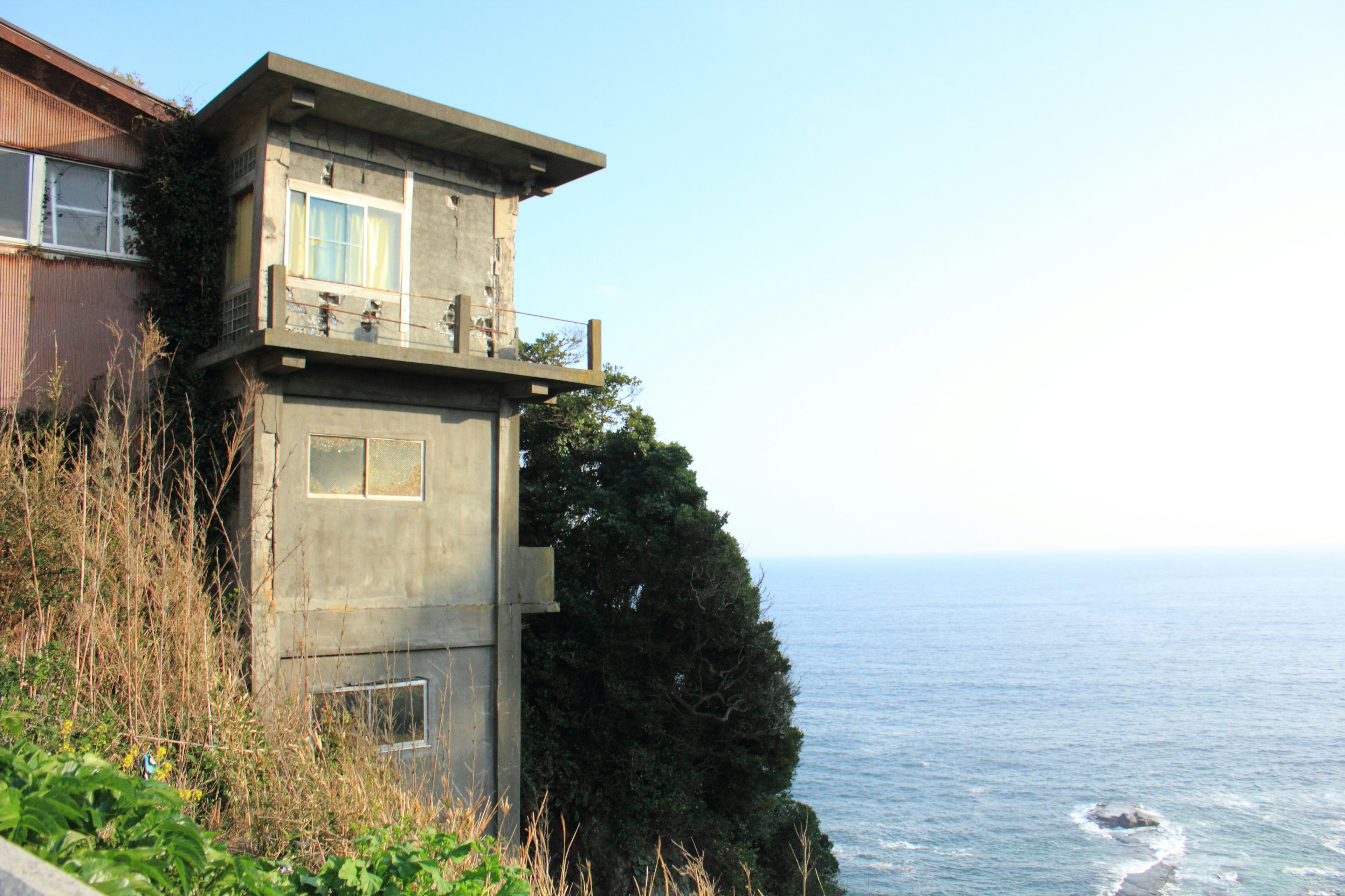 Außenansicht eines Betonhauses an einer Klippe am Meer