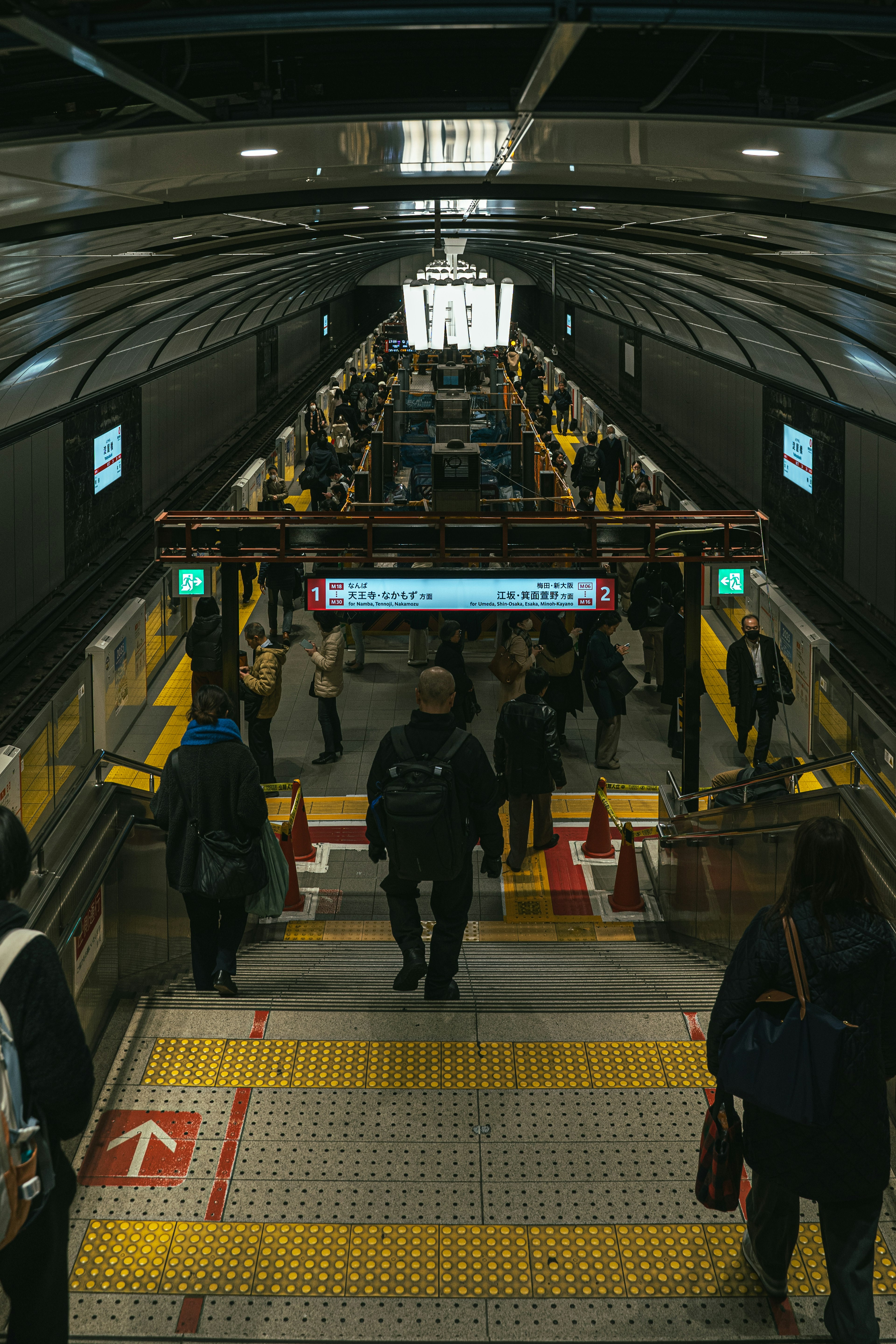 ผู้คนจำนวนมากเดินลงบันไดในสถานีรถไฟฟ้าใต้ดิน