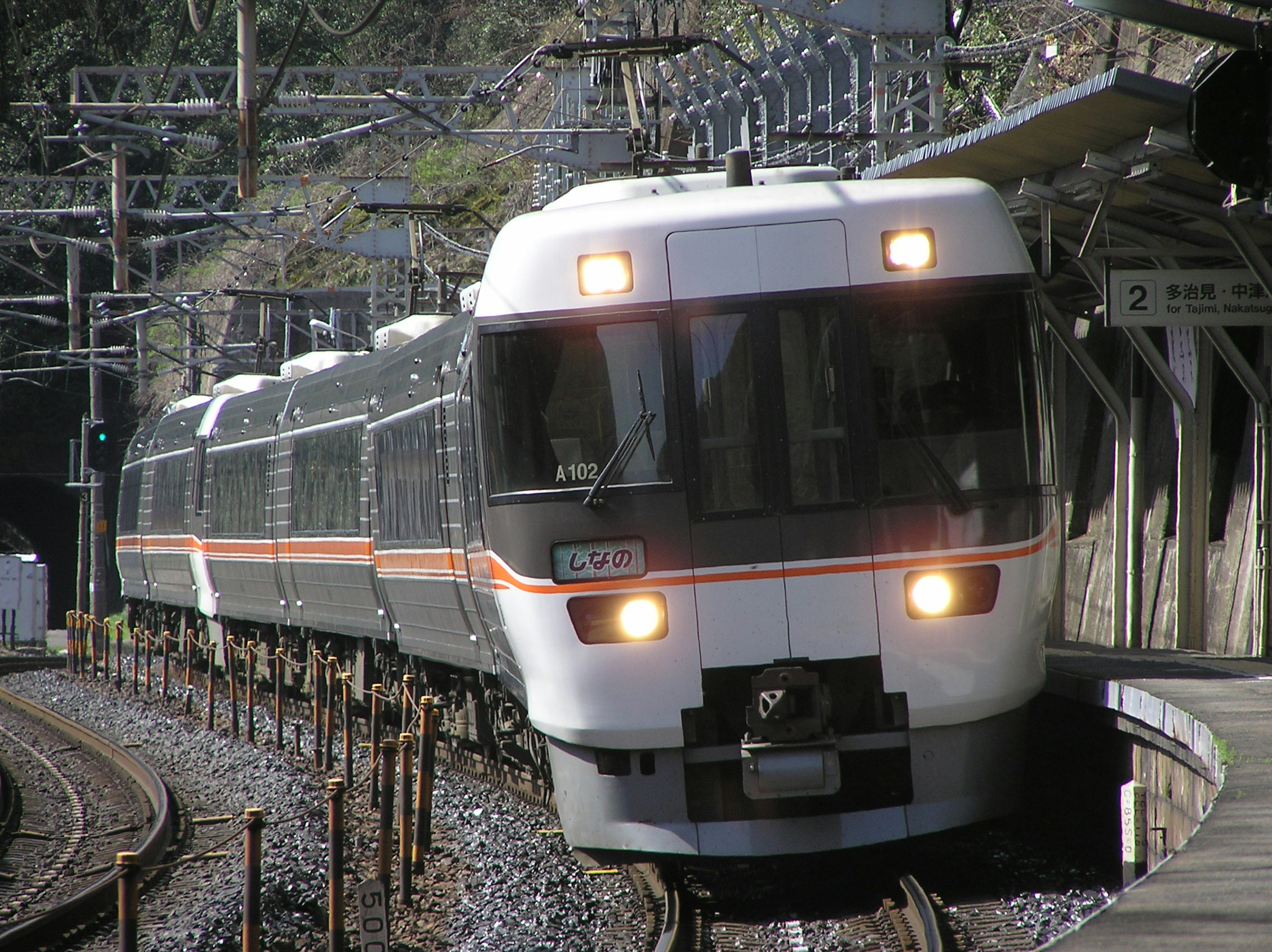 A white and black train approaching a station